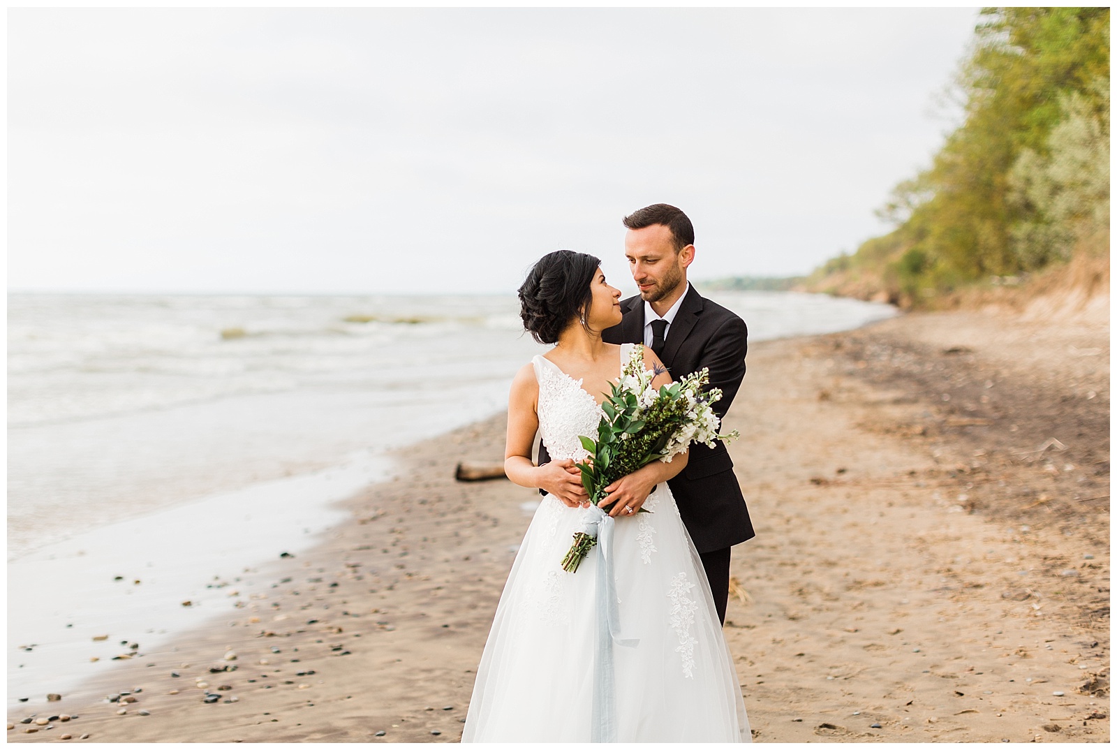 Bride and groom embrace during Northern Michigan beach wedding.