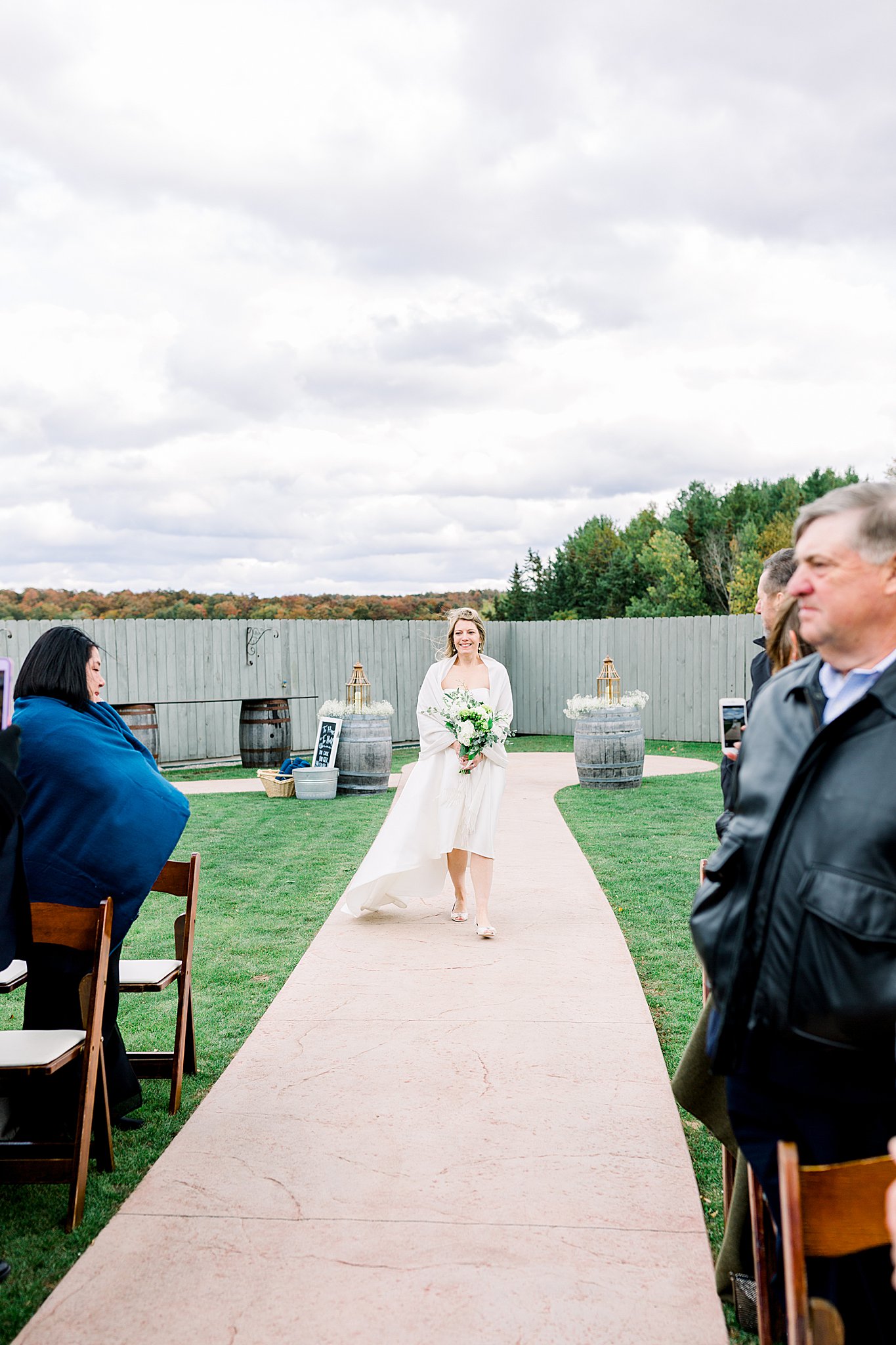 Bride walks down the aisle during terrace ceremony at Aurora Cellars wedding.