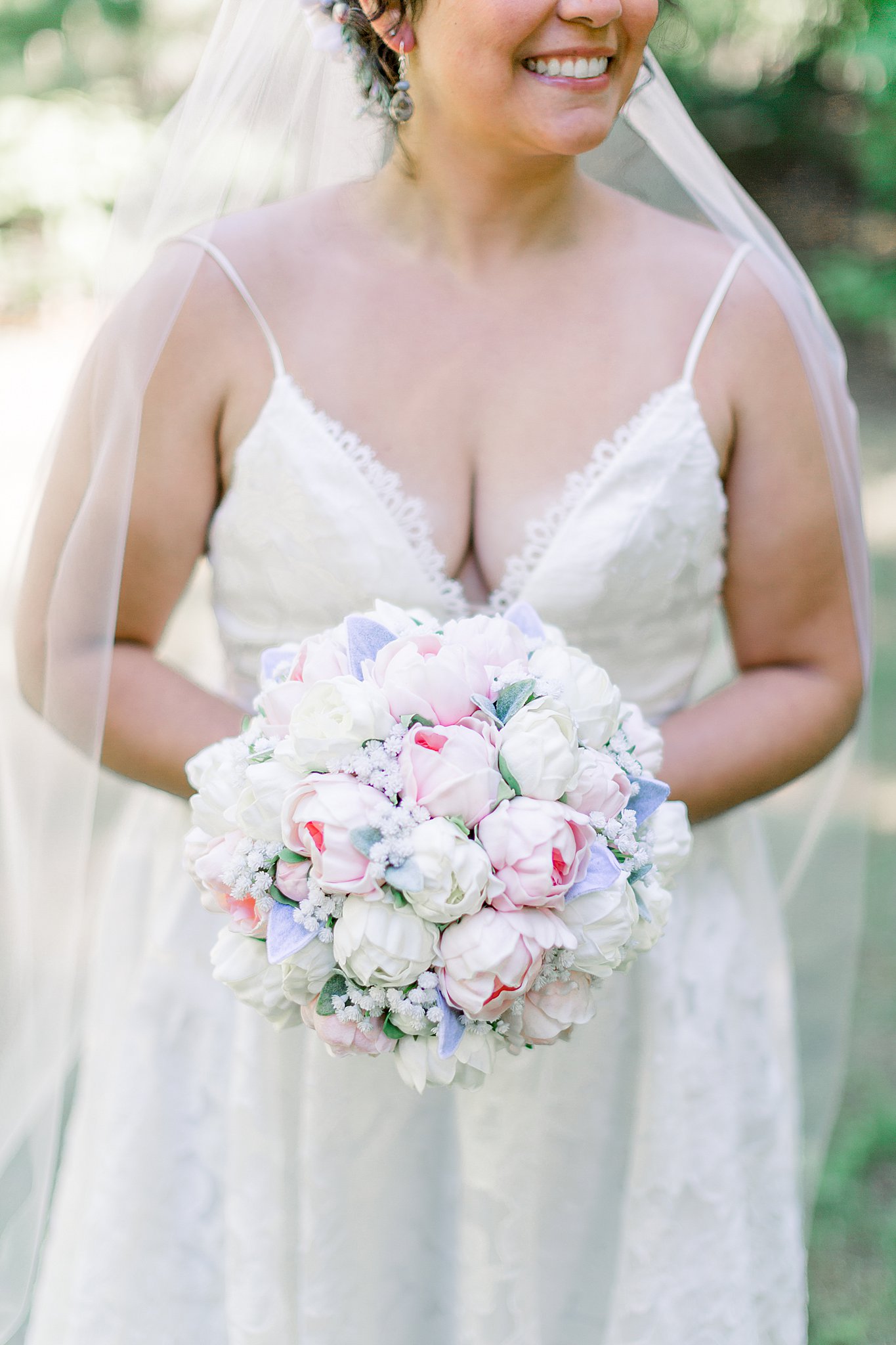 Bride smiling while holding bouquet during Northern Michigan Intimate Wedding