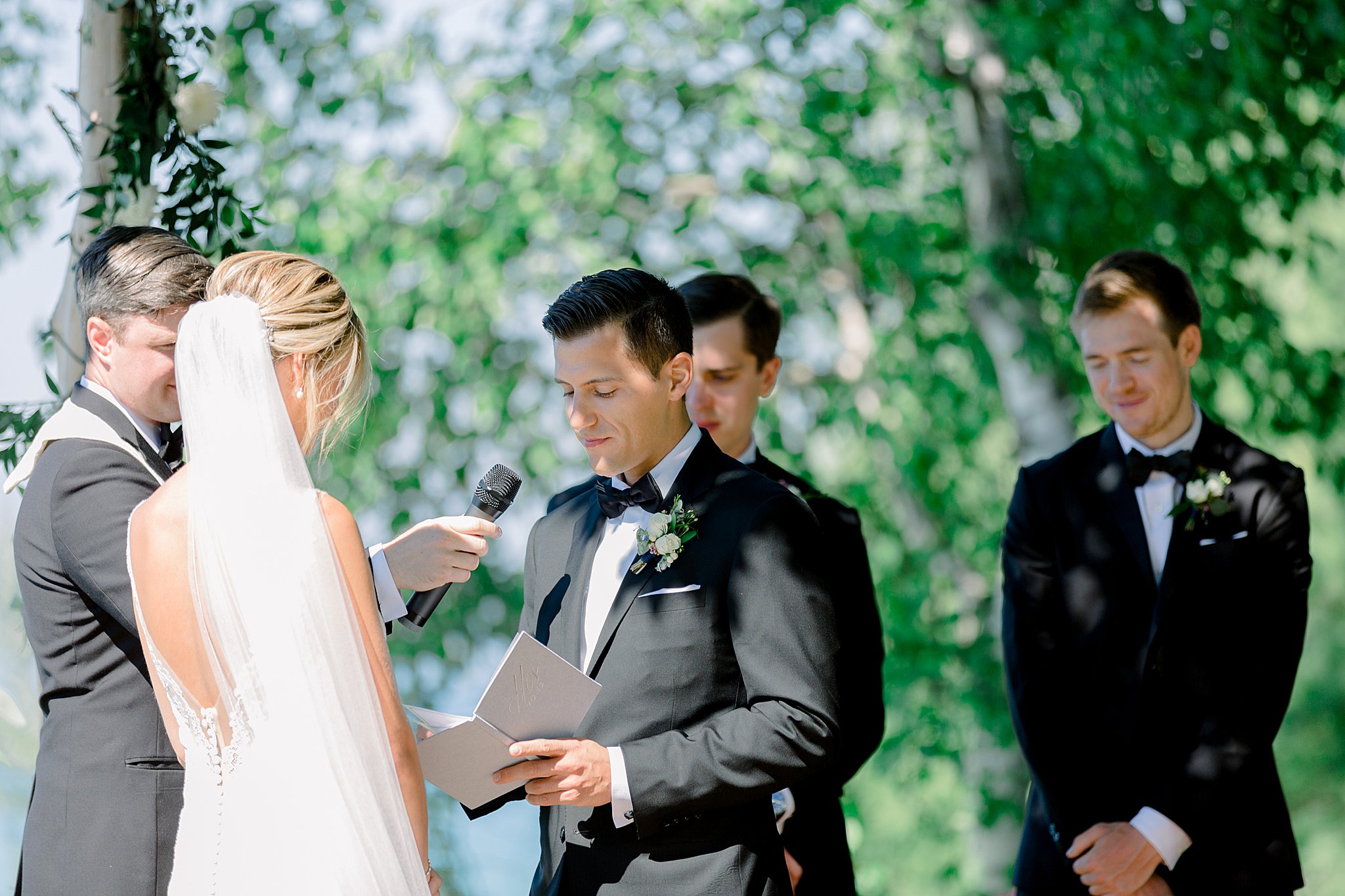 Groom reads vows during intimate Lake Michigan wedding ceremony.