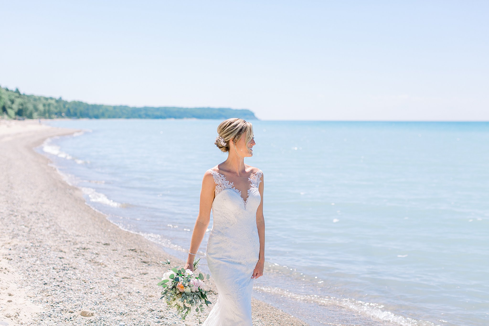 Bride walks along beach at intimate Lake Michigan wedding.