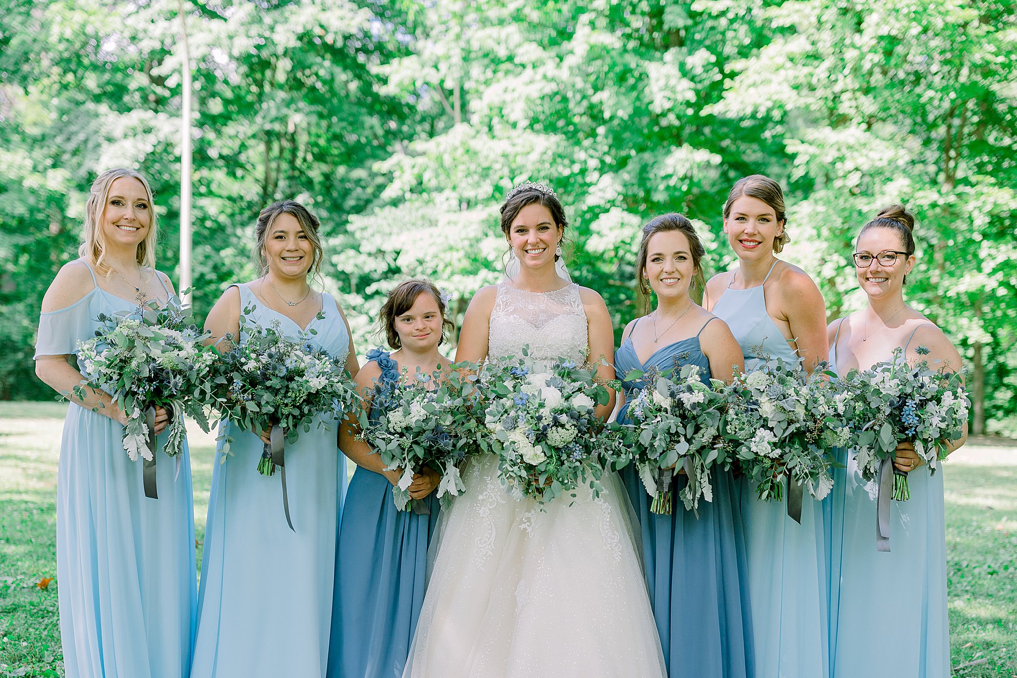 Bride and her bridesmaids smile for pictures during Michigan July wedding.