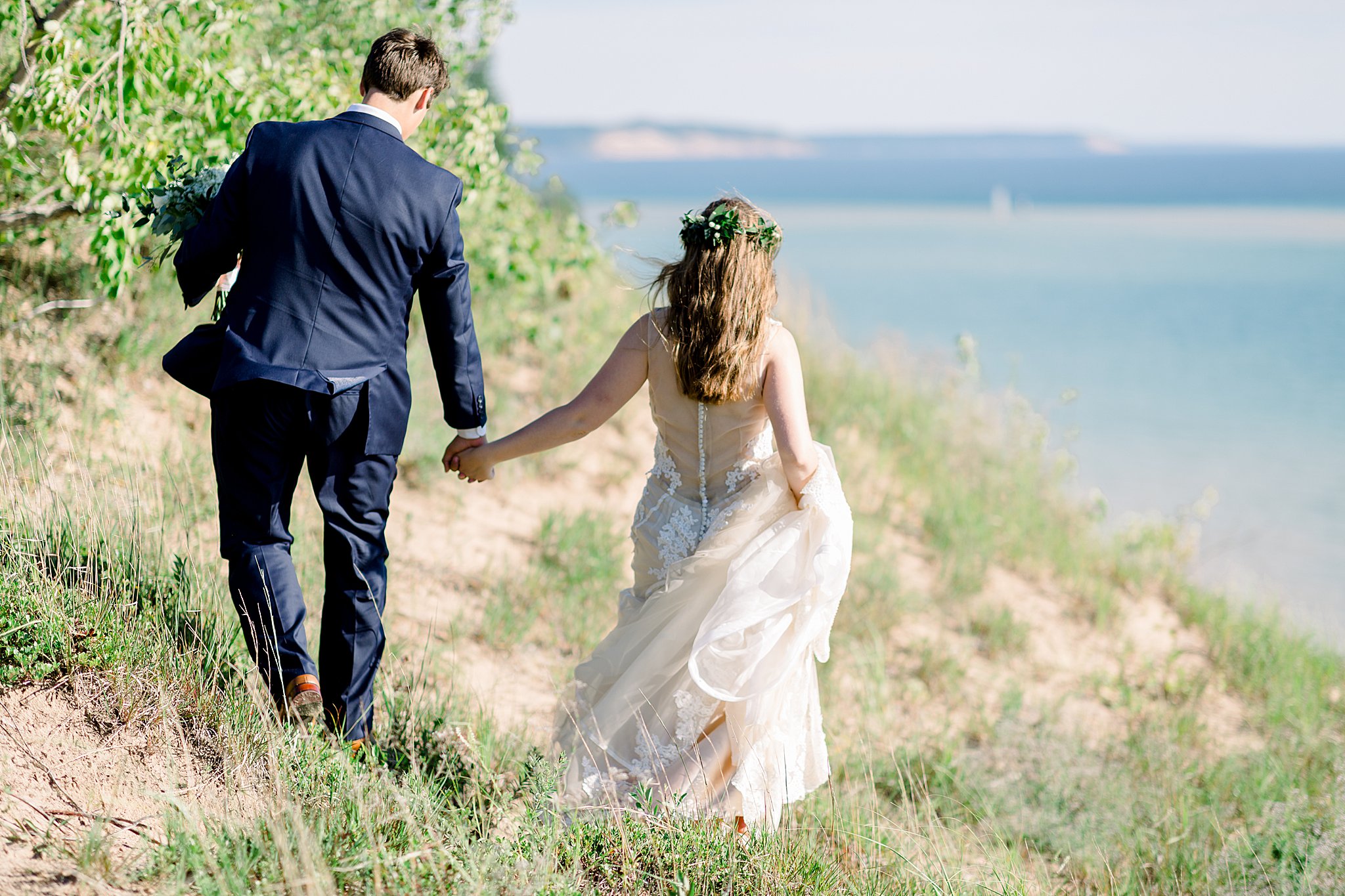 Bride and groom explore Lake Michigan sand dunes during Northern Michigan elopement.