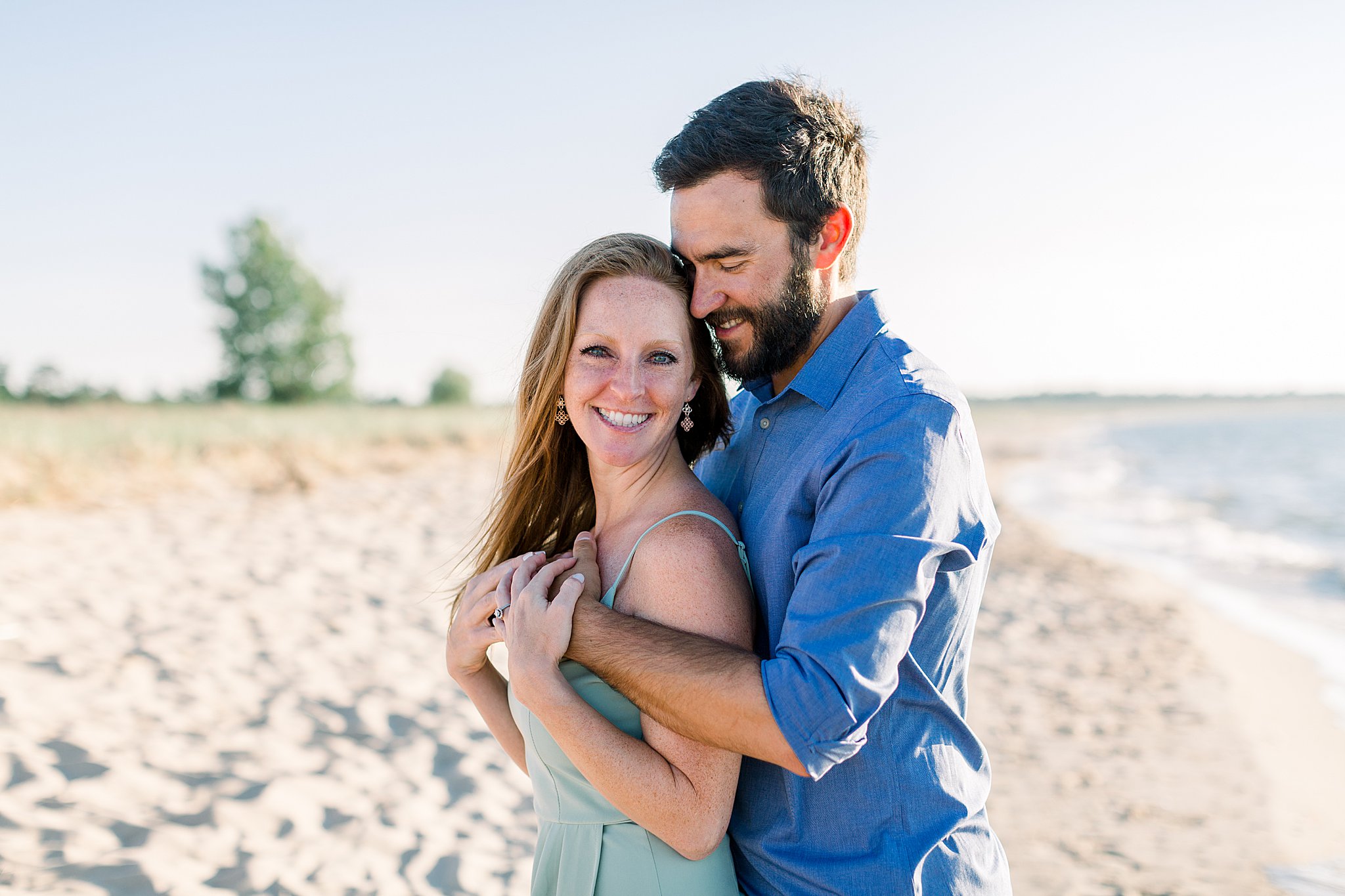 Groom smiles down at bride during Peterson Beach Sleeping Bear Dunes engagement session.