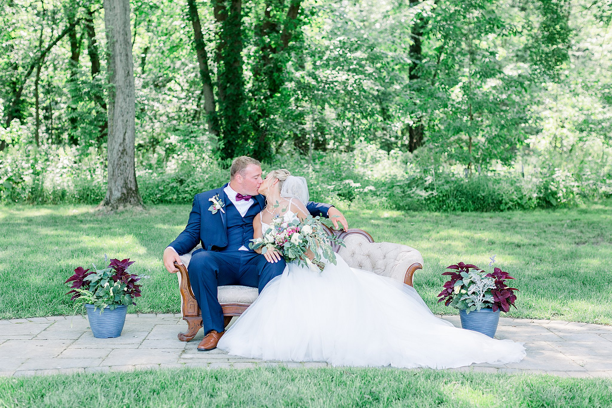 Bride and groom kiss on couch during Post Family Farm Wedding