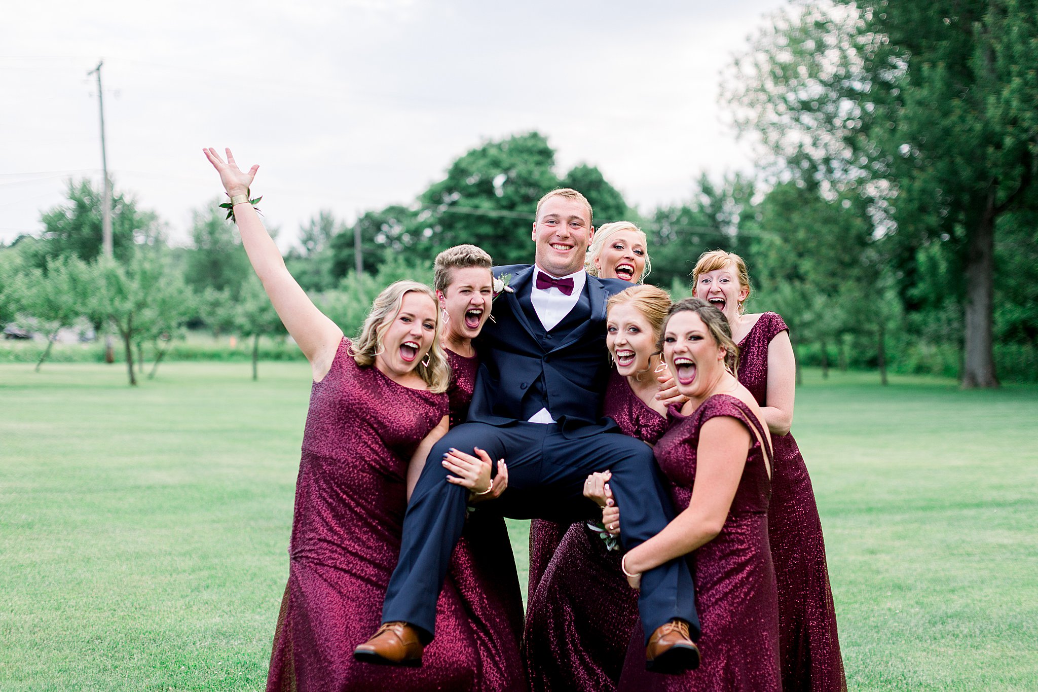 Bridesmaids hold groom and shout during Post Family Farm Wedding