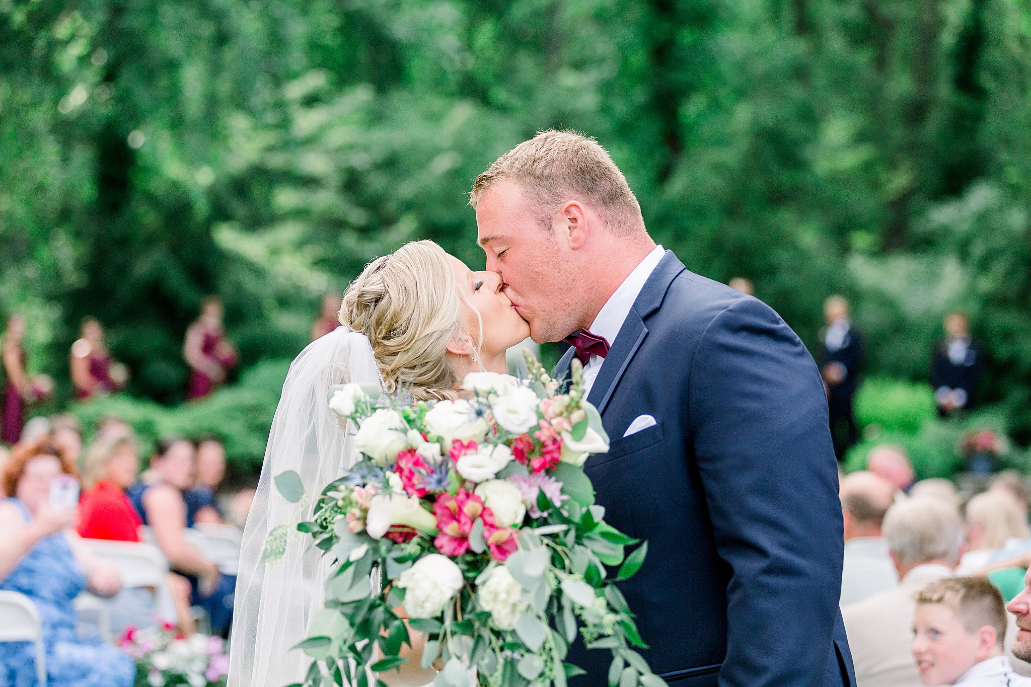 Bride and groom kiss while walking back up the aisle after Post Family Farm Wedding