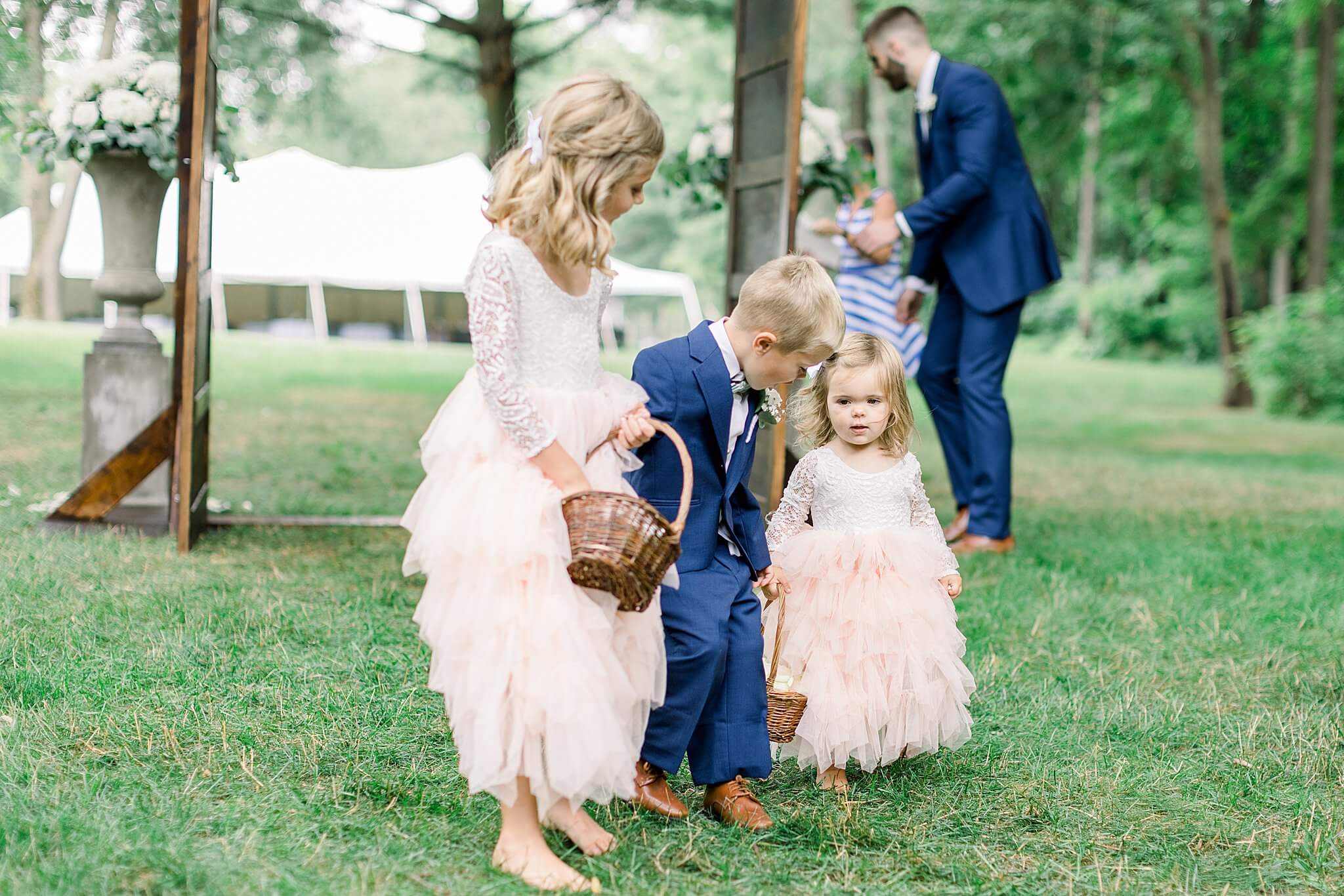Flower girl makes her way down the aisle during summer backyard wedding in Northern Michigan.