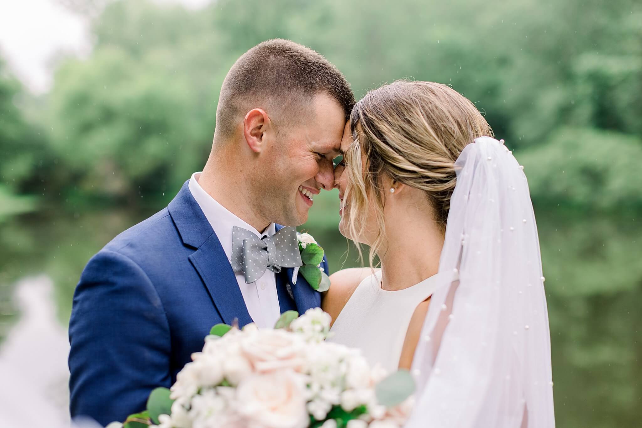 Bride and groom smile at each other during summer backyard wedding in Northern Michigan.
