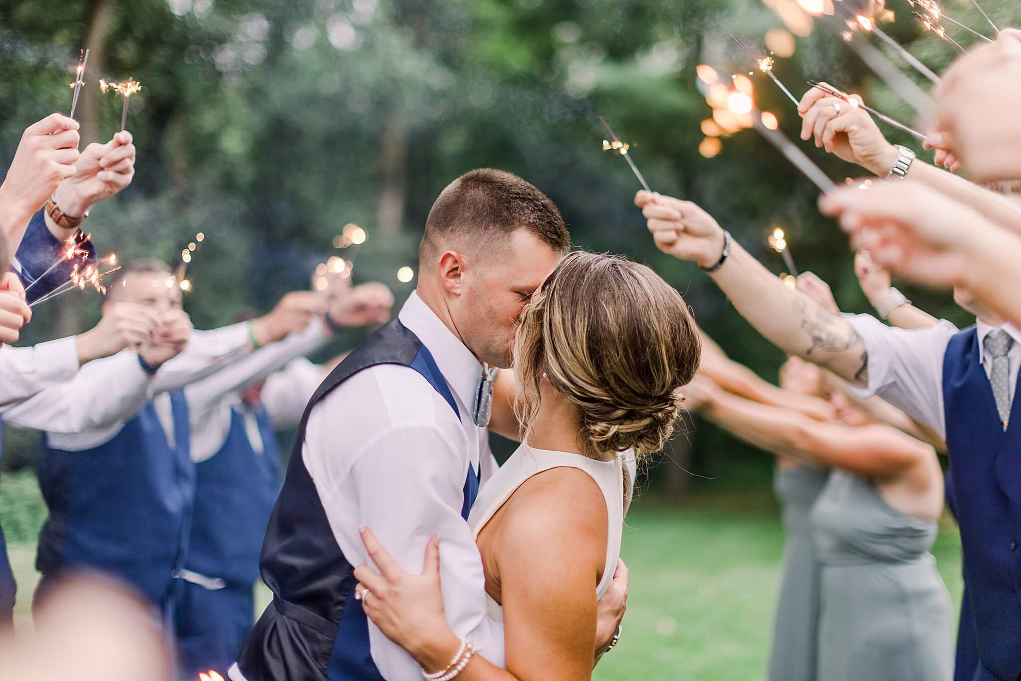 Bride and groom kiss during sparkler exit during summer backyard wedding in Northern Michigan.