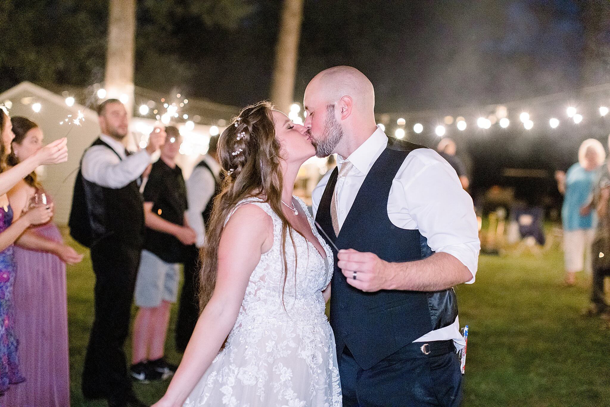 Bride and groom kiss during sparkler exit at Michigan Summer Backyard Wedding