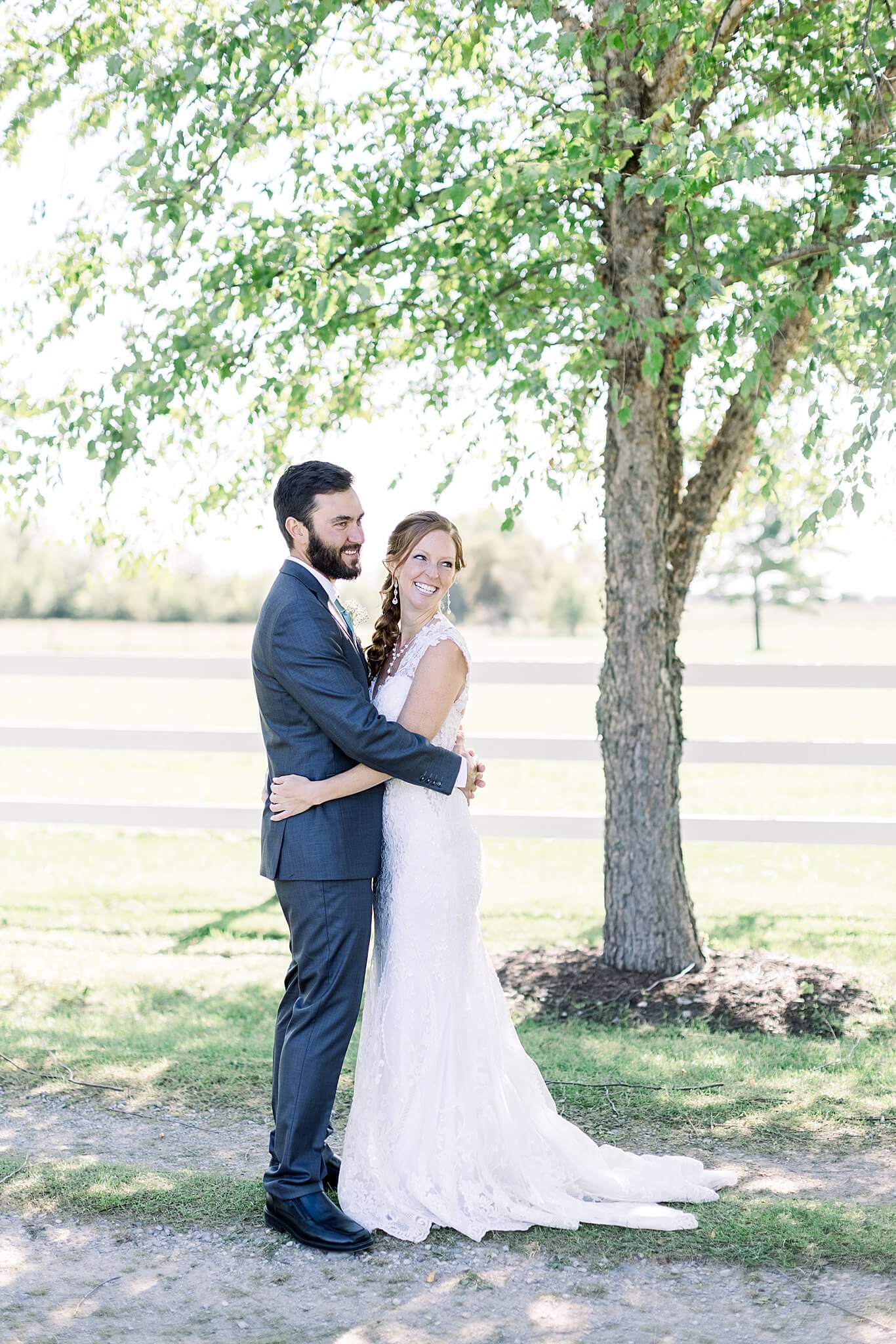 Bride and groom embrace and smile during first look at Crooked Creek Ranch wedding.