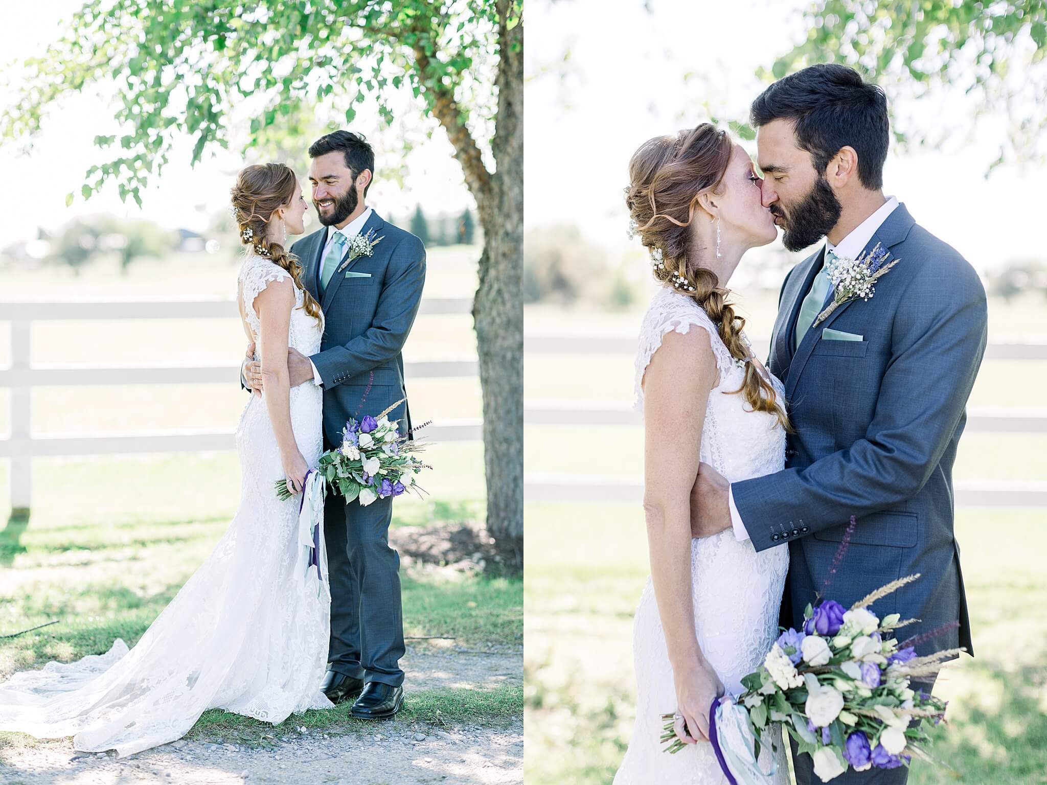 Groom kisses bride under a tree during Crooked Creek Ranch wedding.