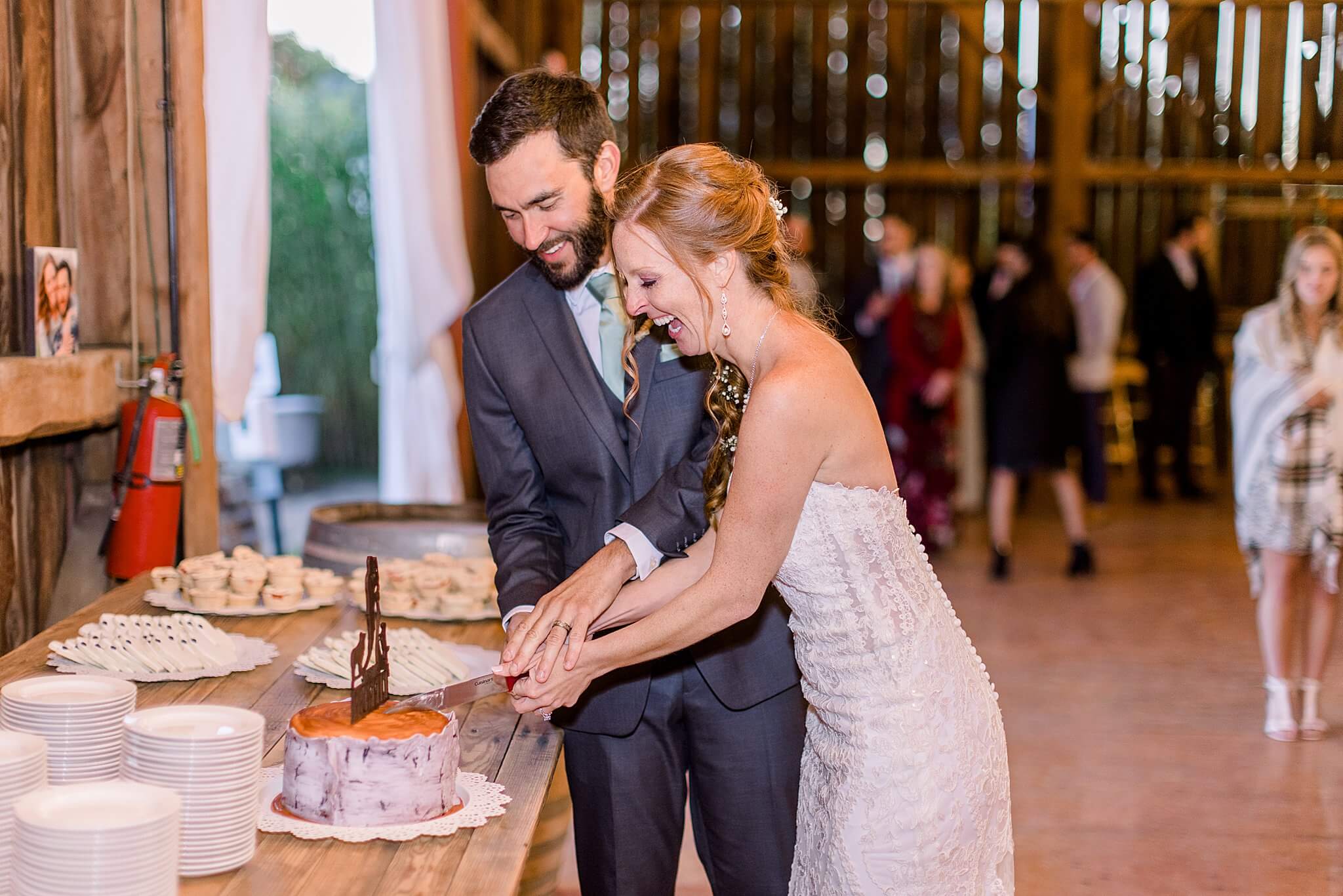 Bride and groom cut cake during Crooked Creek Ranch wedding reception.