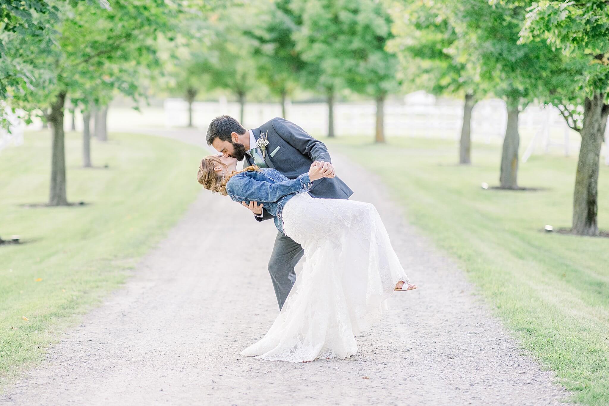 Groom dips bride for a kiss during Crooked Creek Ranch wedding.