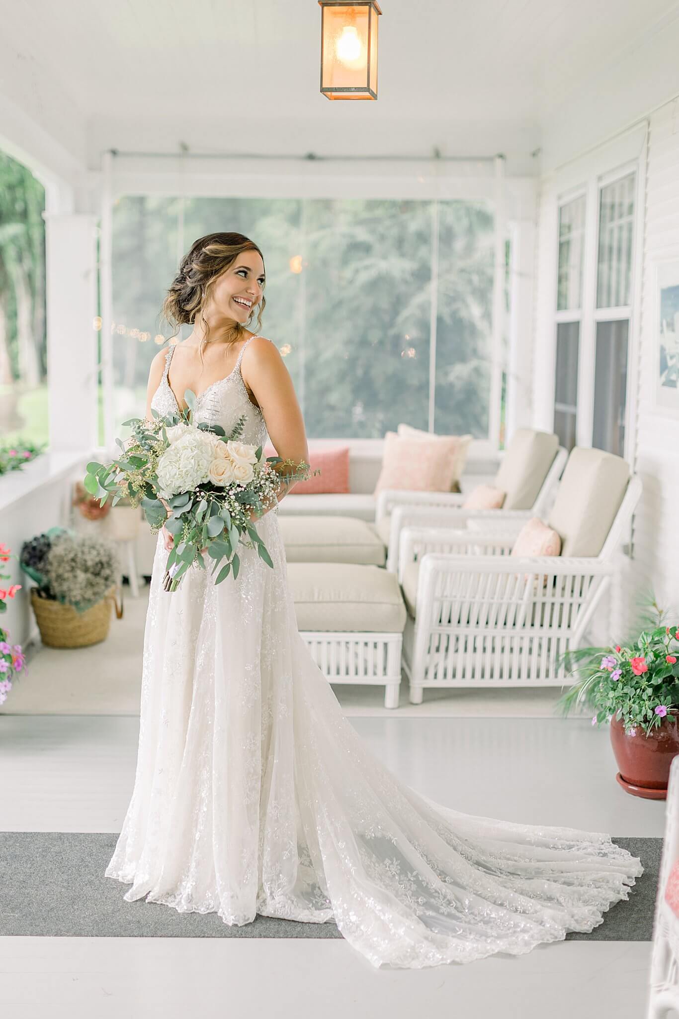 Bride smiles with bouquet during rainy Intimate Northern Michigan Wedding day.