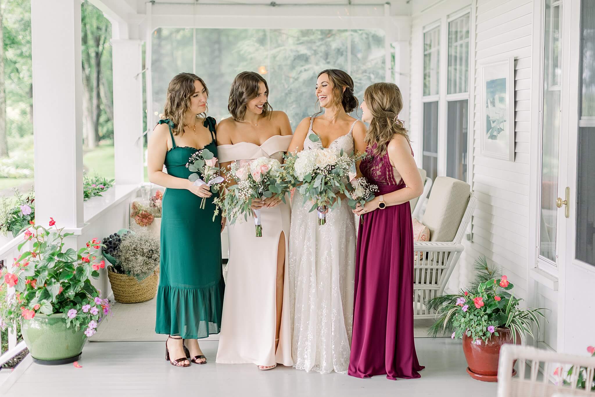 Bridesmaids laugh with bride during rainy day portraits for Intimate Northern Michigan Wedding.