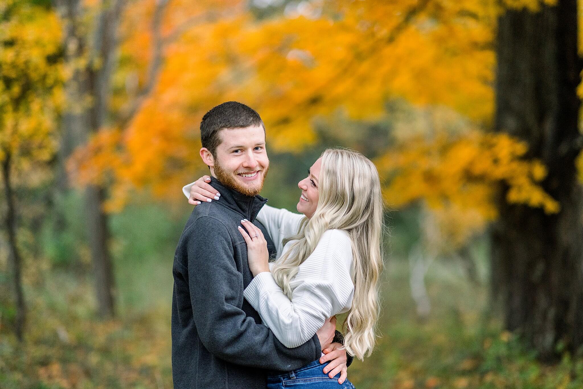 Groom smiles at camera during M22 Fall Engagement Session in Northern Michigan.