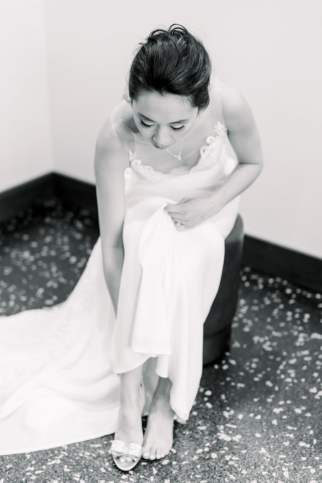 Bride puts on her shoes as she prepares for her elegant Grand Rapids wedding.