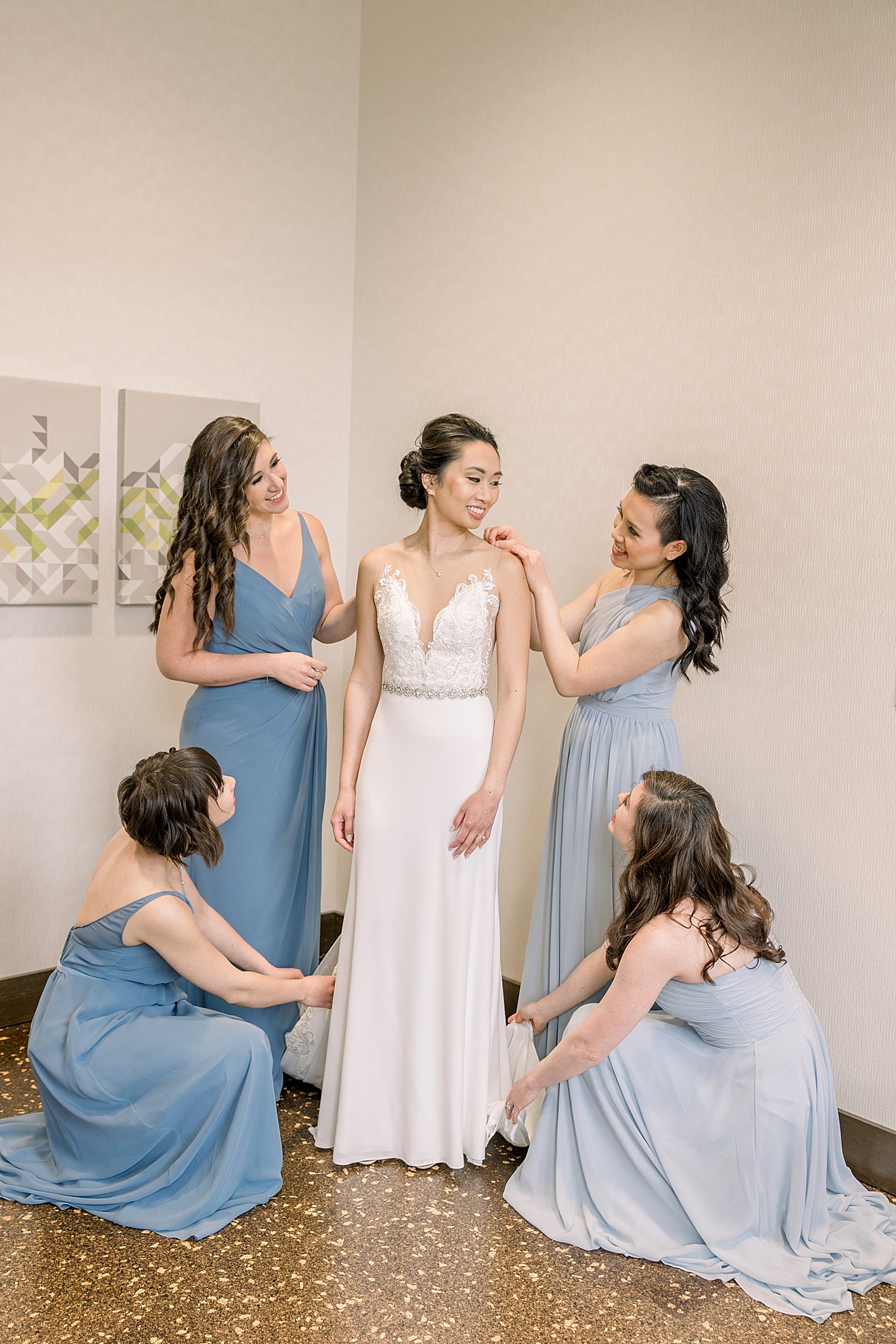 Bridesmaids help bride get dressed for her elegant Grand Rapids wedding.