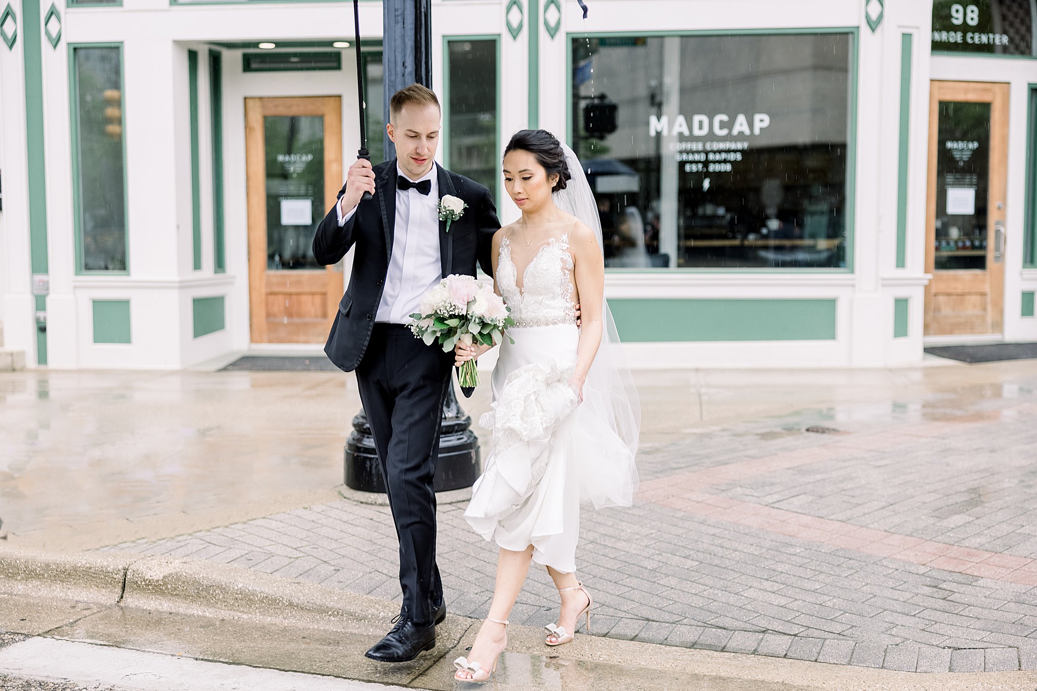 Bride and groom cross street in front of Madcap during elegant Grand Rapids wedding.