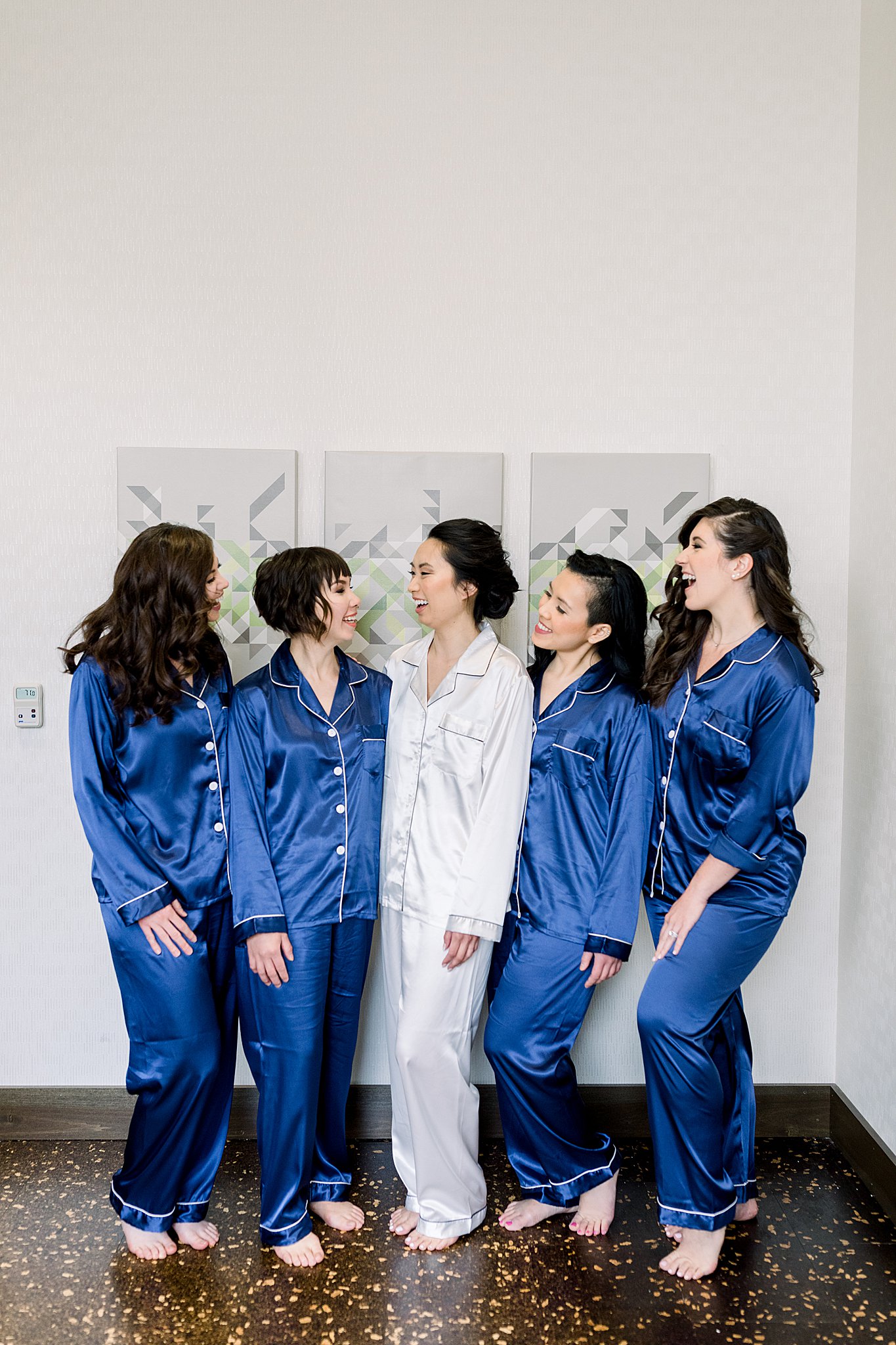 Bride laughs with bridesmaids in matching robes during elegant Grand Rapids wedding.