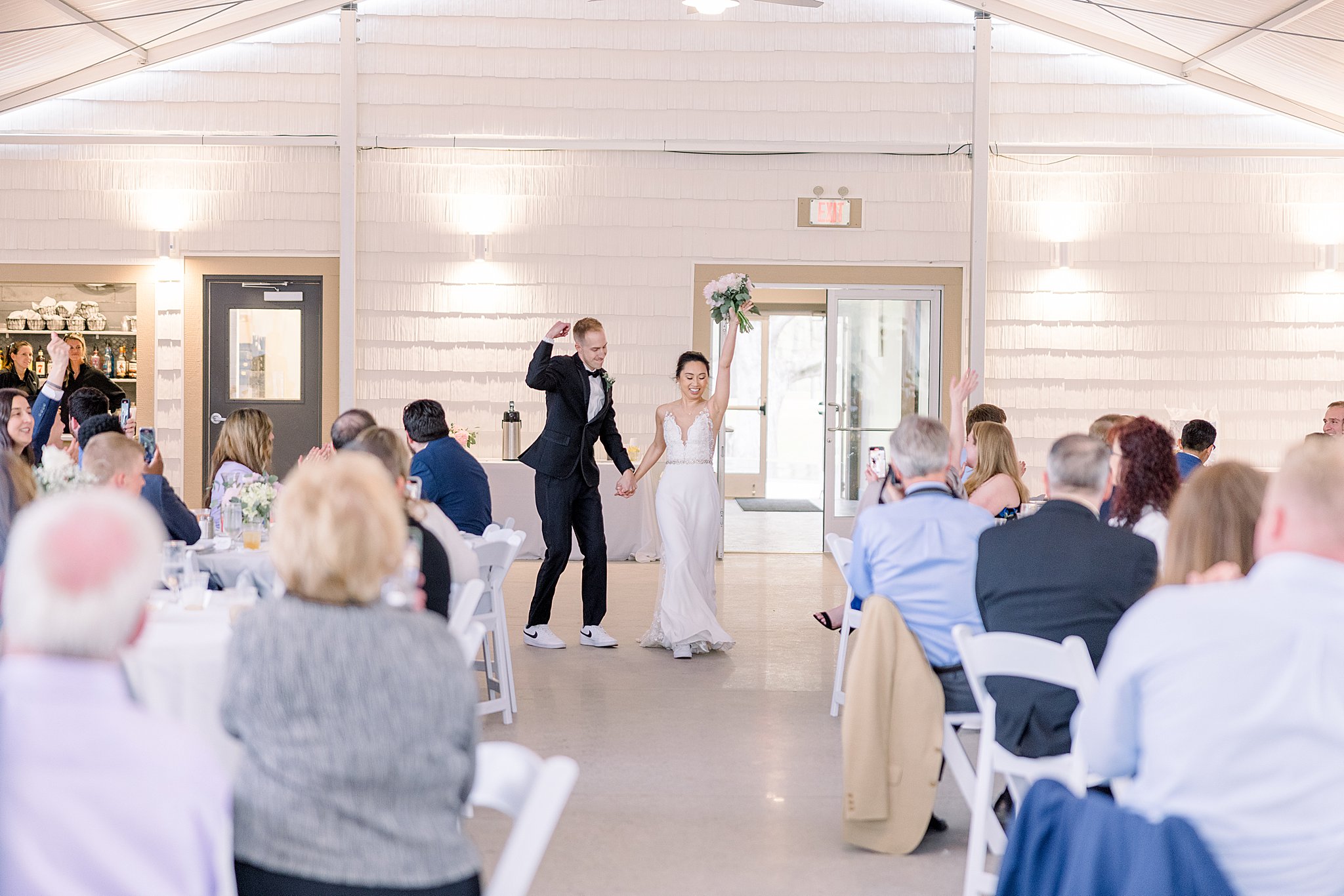 Bride and groom dancing during grand entrance at elegant Grand Rapids wedding.