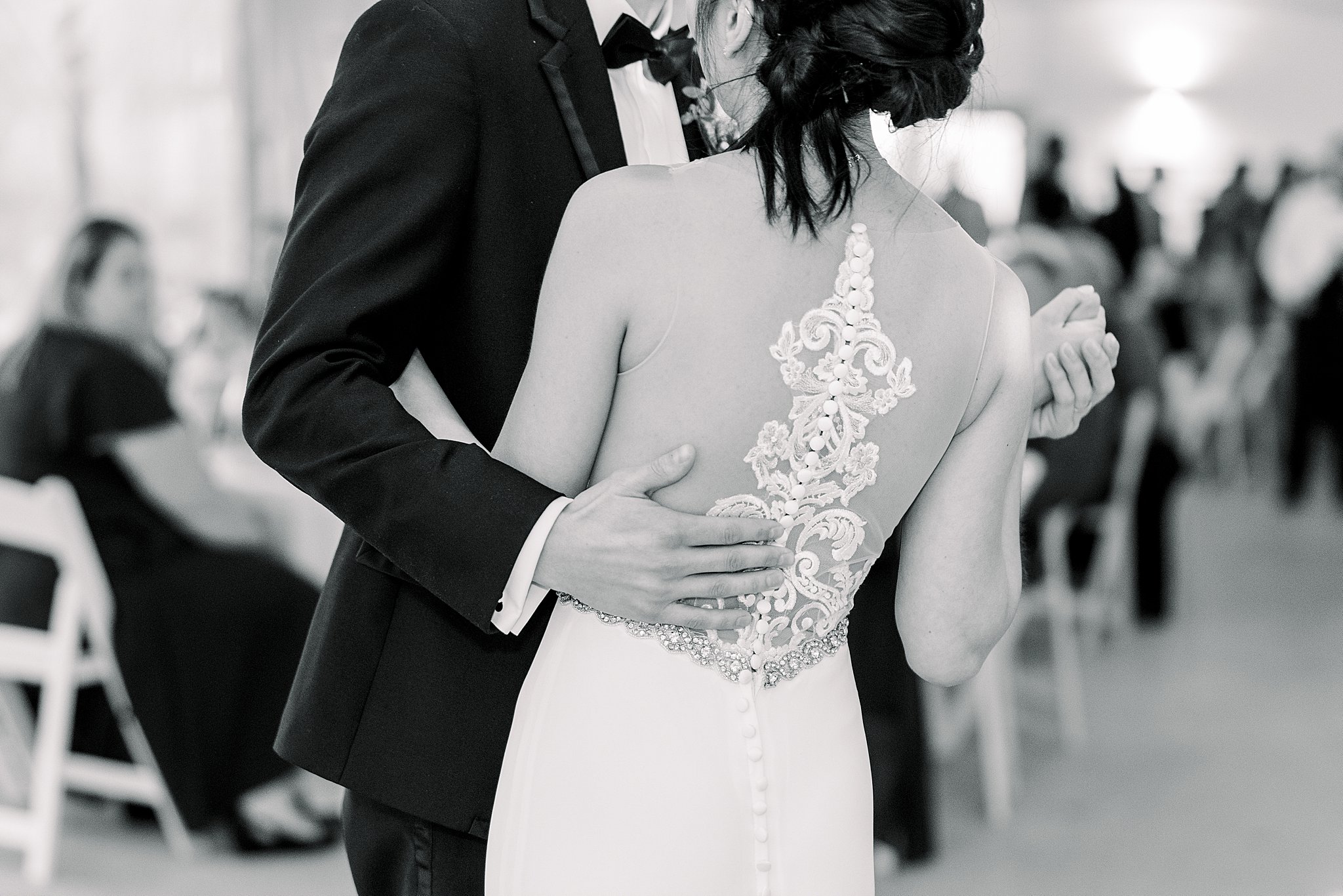 Black and white shot of lace on bride's dress during first dance at elegant Grand Rapids wedding.