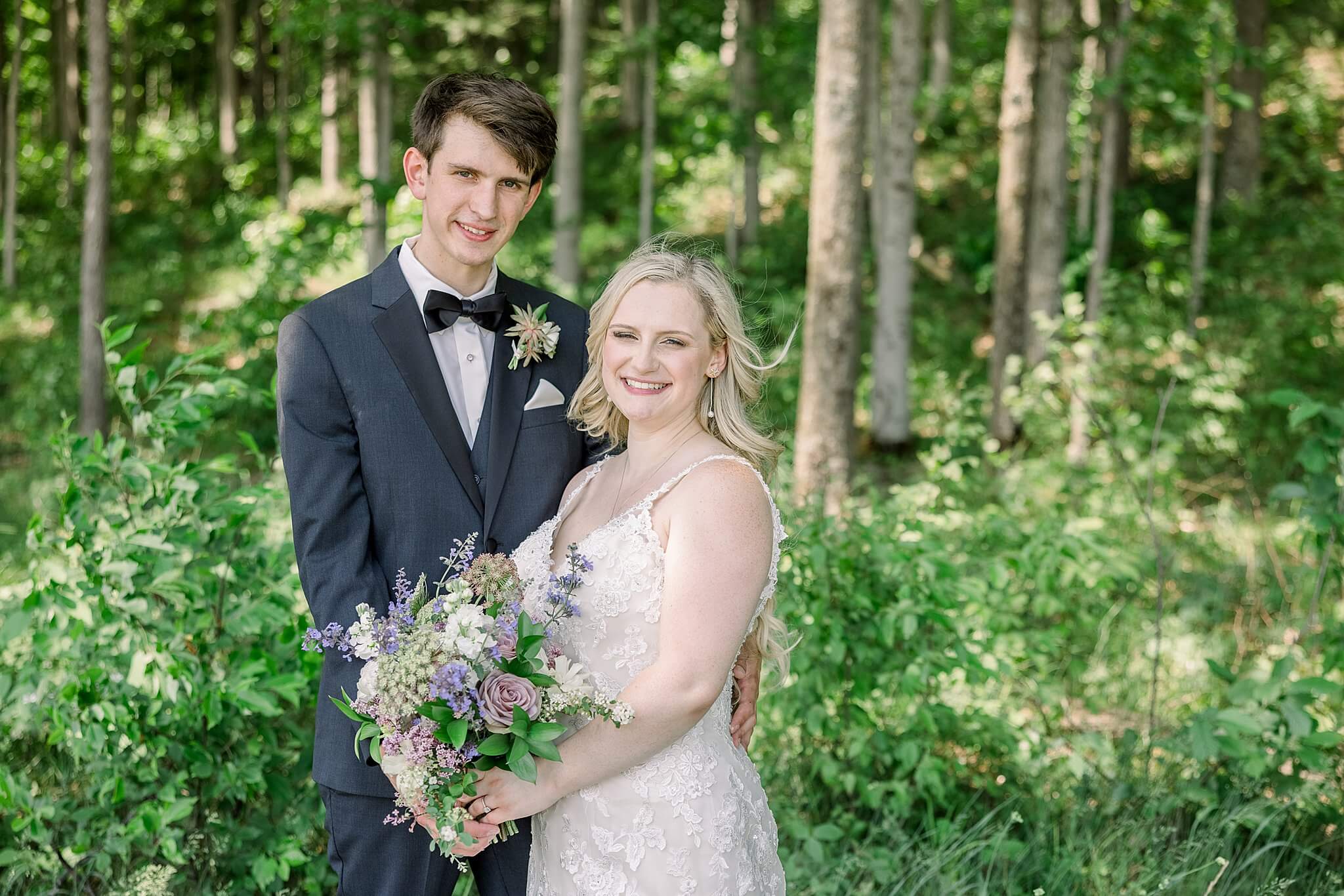 Bride and groom smiling in forest at Nature Michigan wedding.