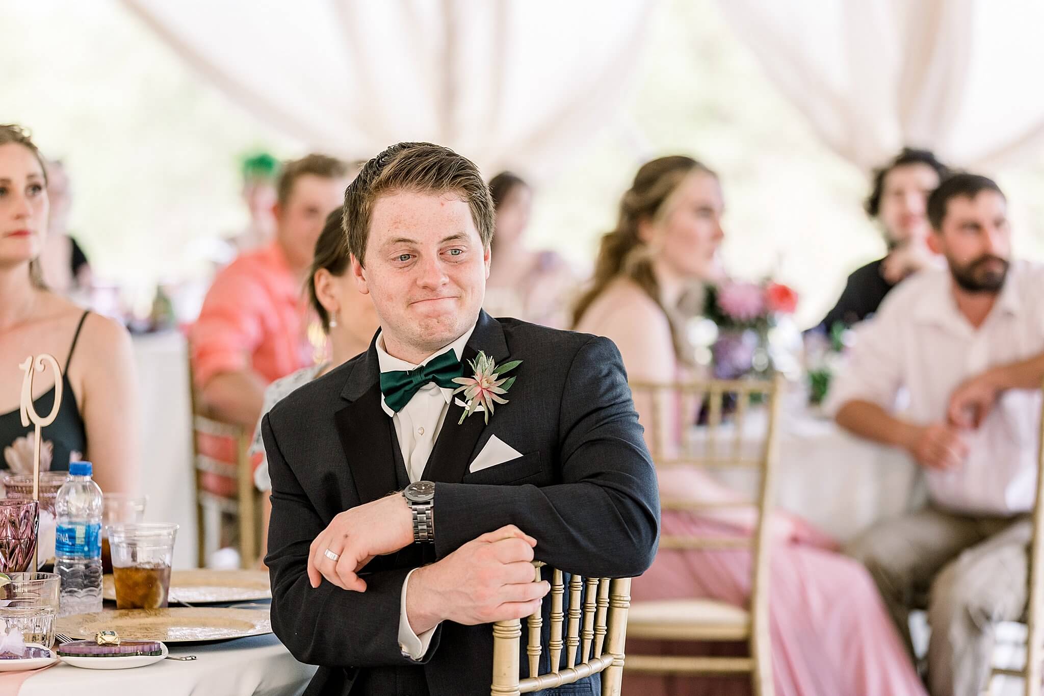 Groomsman reacts during toasts at Nature Michigan wedding.