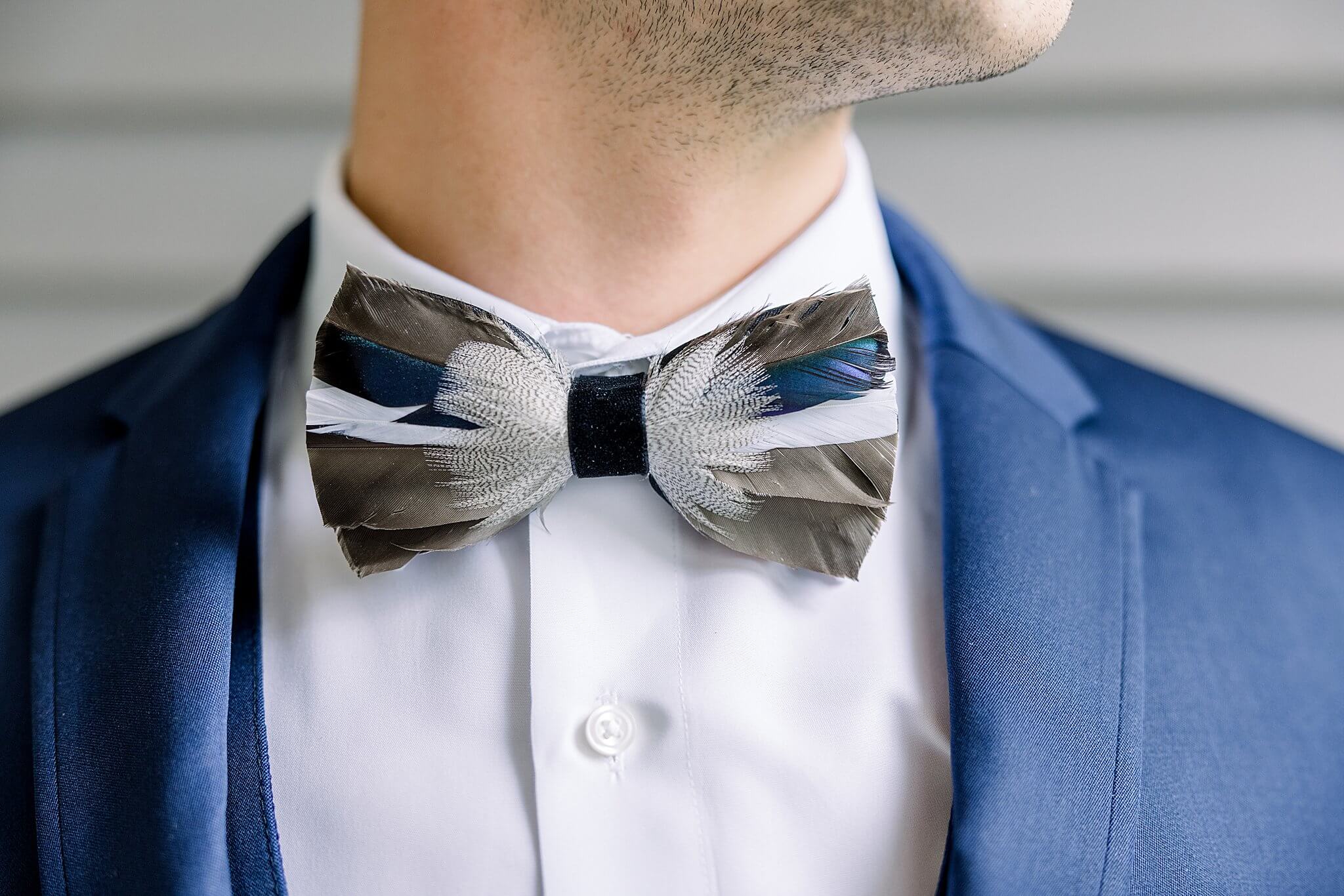 Groom sports custom duck feather bow tie for Traverse City wedding.