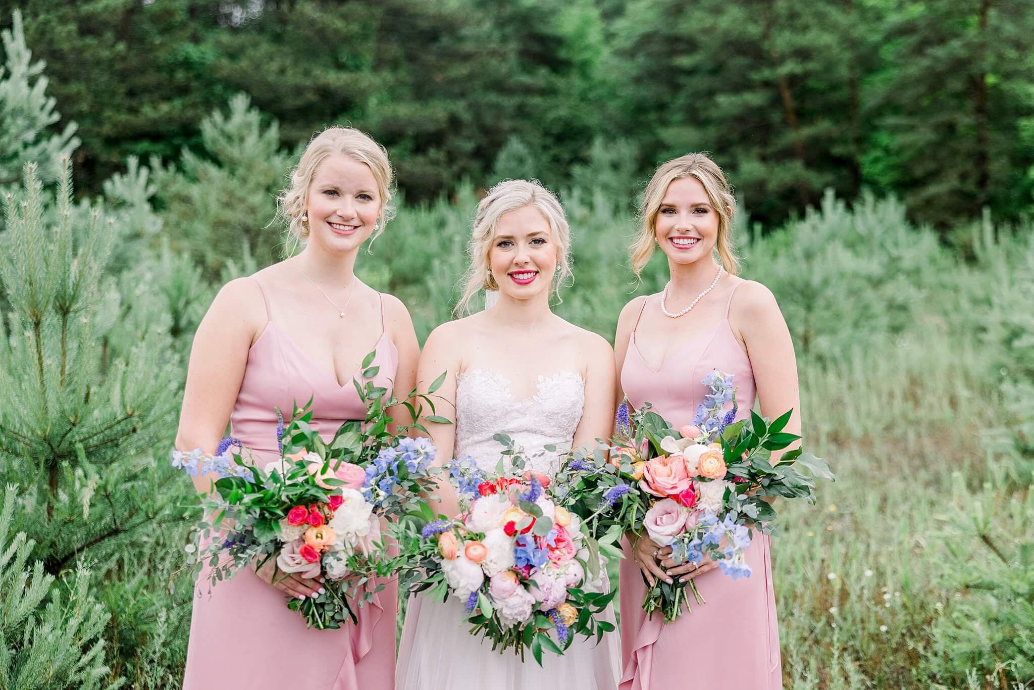 Traverse City bride posing with her bridesmaids and their bold, colorful wedding florals.