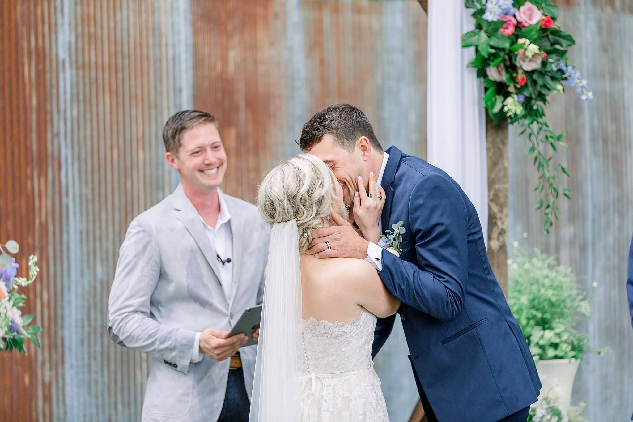 Bride and groom share first kiss during their Traverse City wedding ceremony.