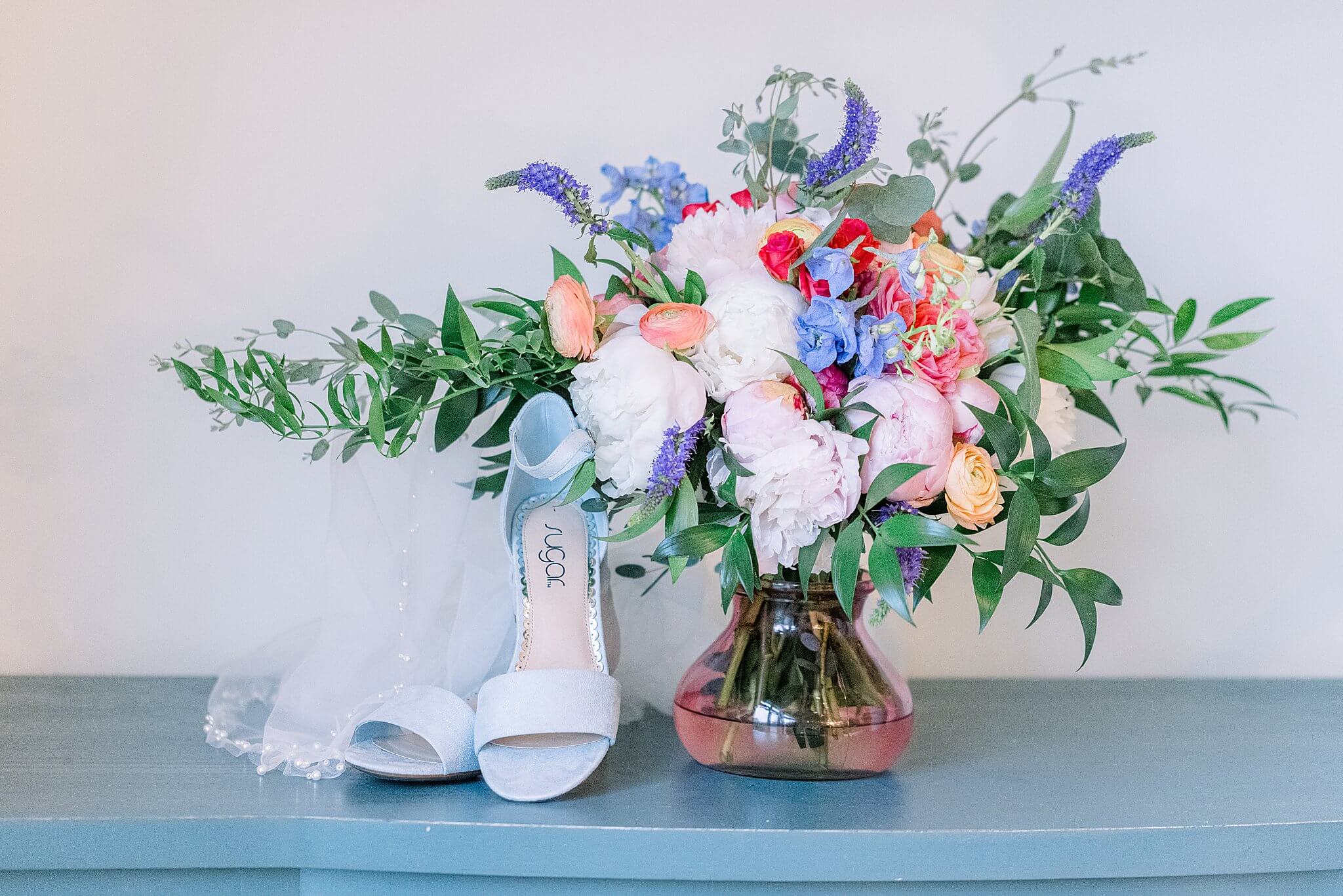 Bold, bright, colorful bouquet sits on top of vintage blue dresser.