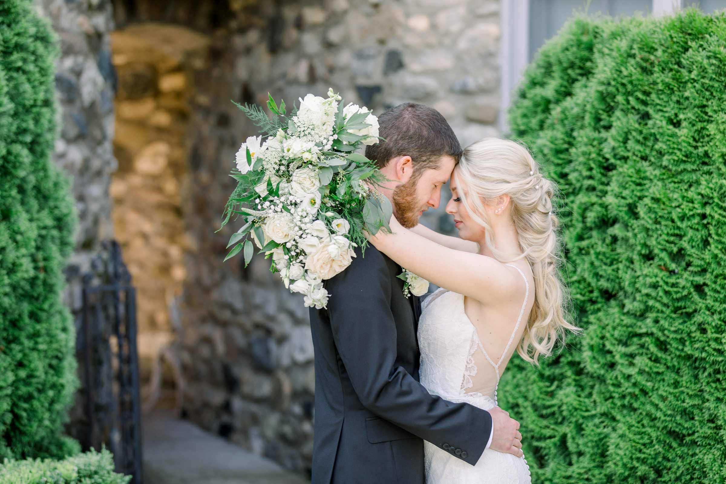 Bride and groom embrace in Butterfly Garden at Castle Farms in Charlevoix, MI