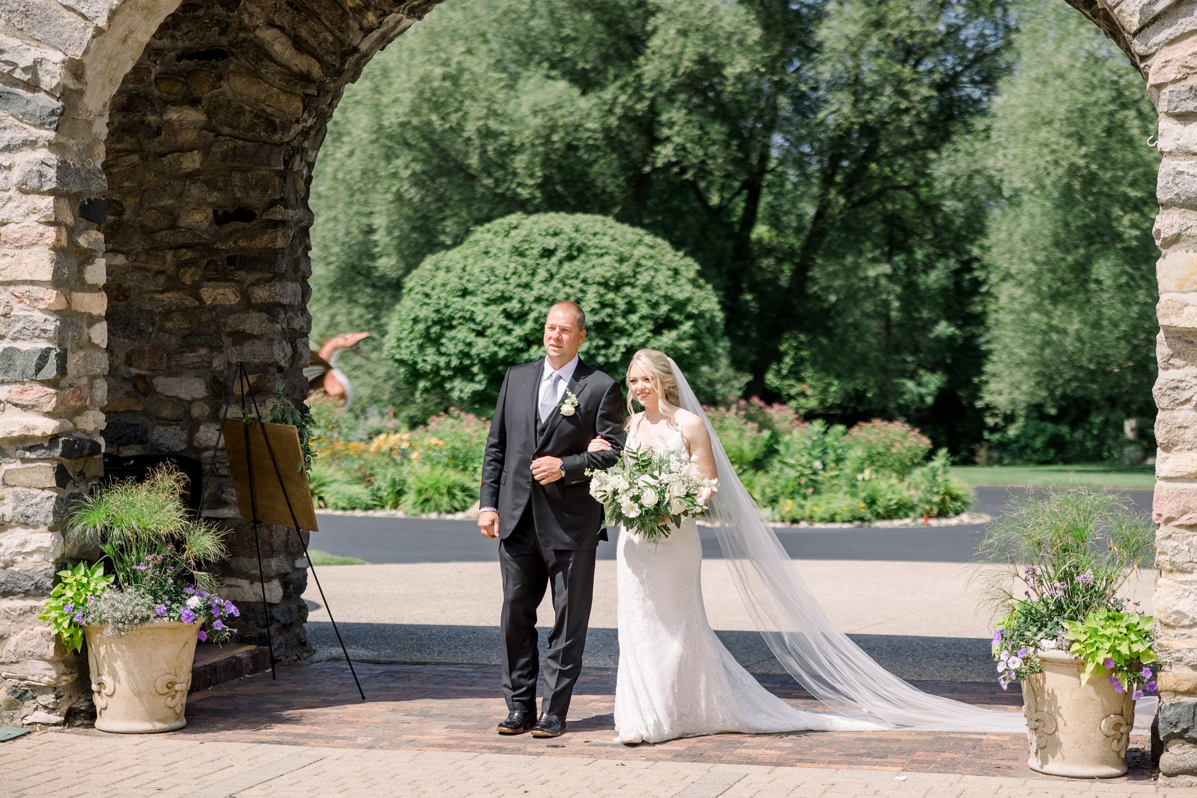 Bride walks down the aisle in Queen's Courtyard at Castle Farms wedding