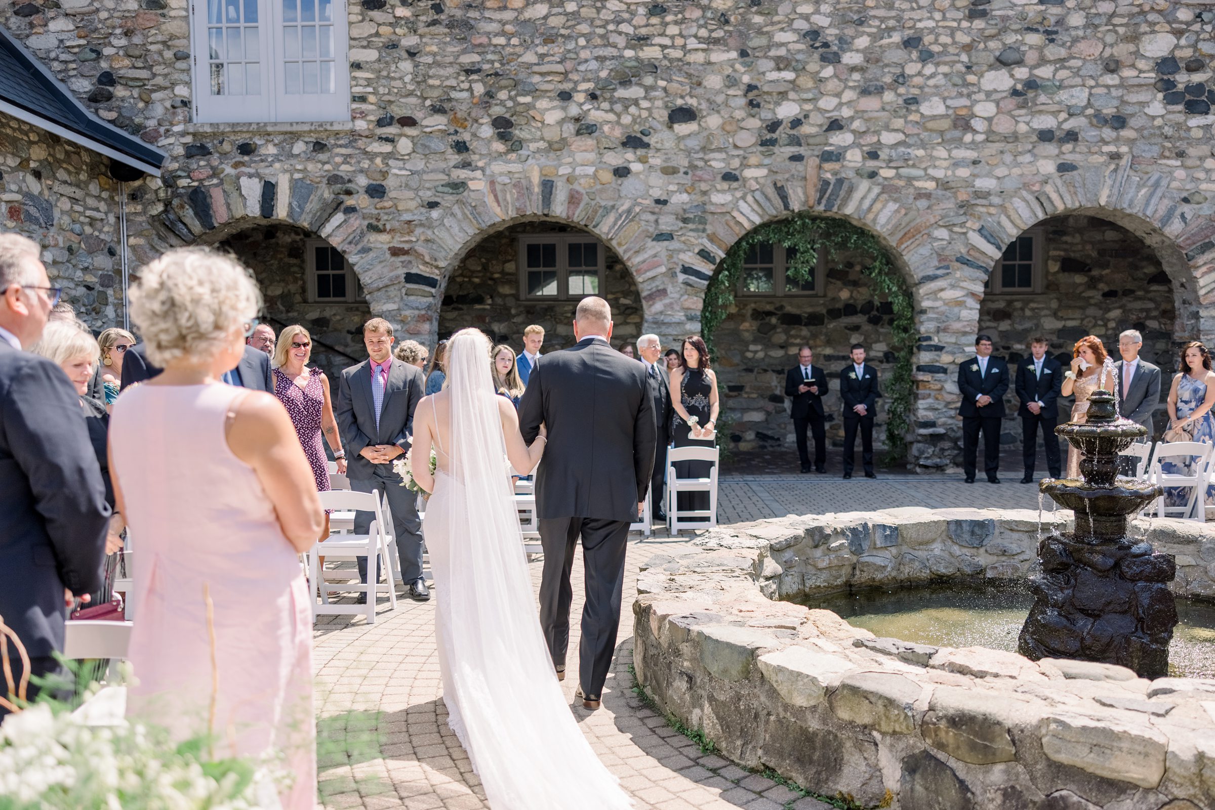 Bride walks down the aisle with her dad during Castle Farms wedding