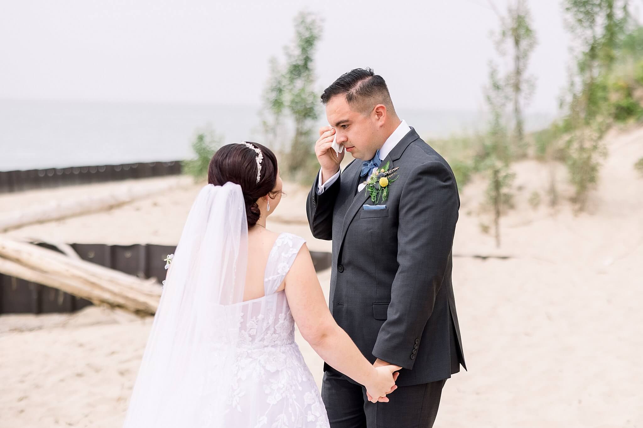 Groom cries during first look on Elberta Life Saving Station wedding day.