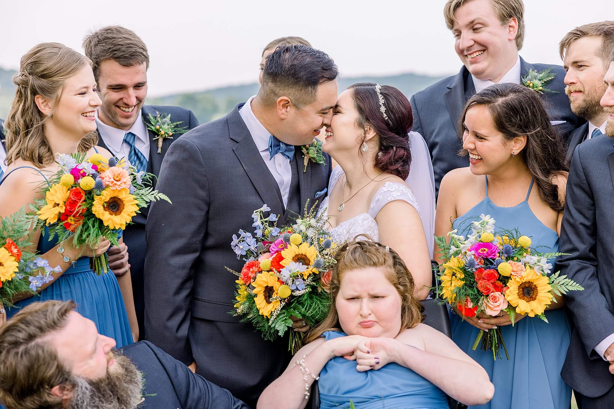 Bride and groom laugh while surrounded by their bridal party at Elberta Life Saving Station Wedding