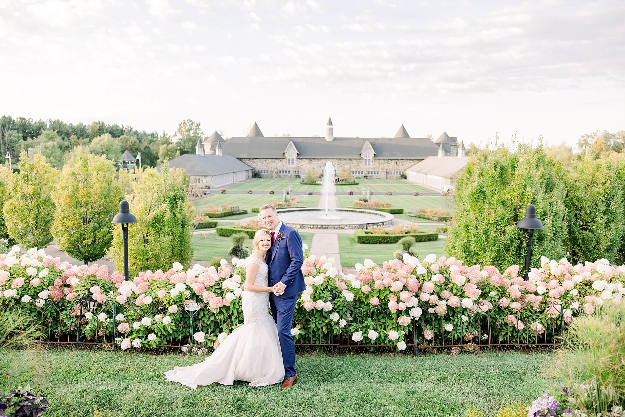 Bride & Groom take pictures in front of blossoms during September Castle Farms wedding.