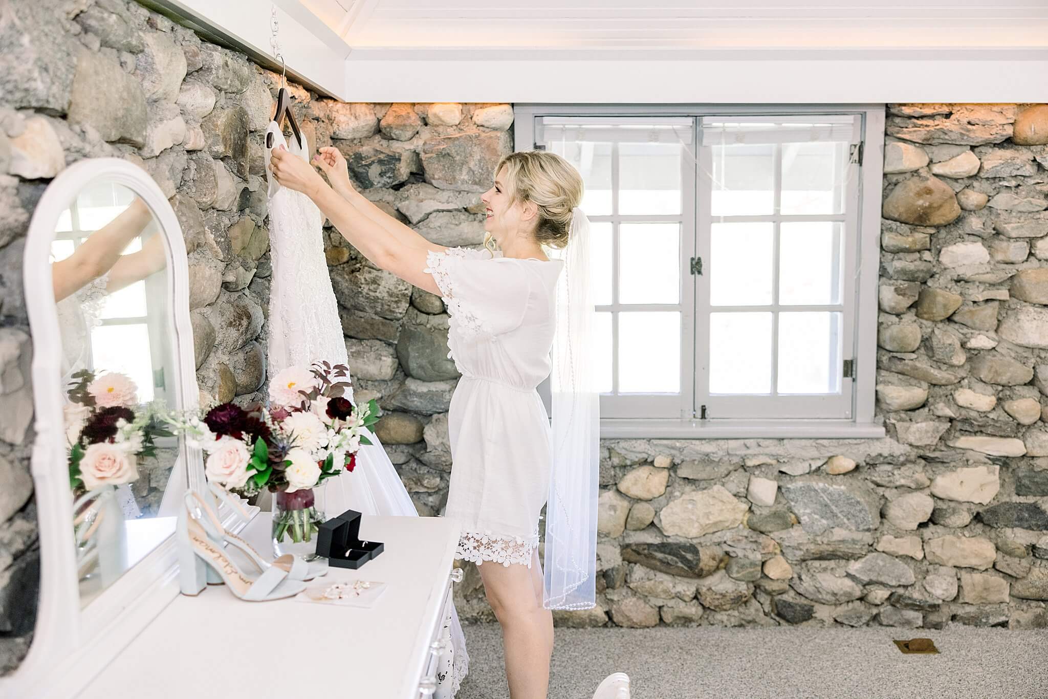 Bride prepares dress to get ready for her Castle Farms wedding day.