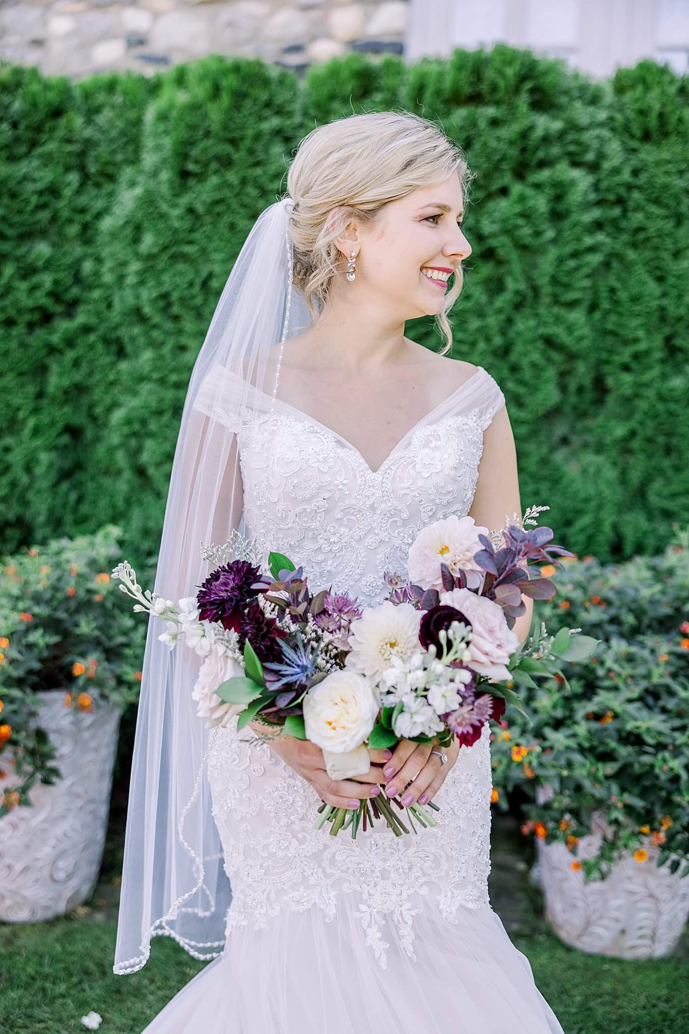 Bride smiles while holding her wedding bouquet at Castle Farms wedding.