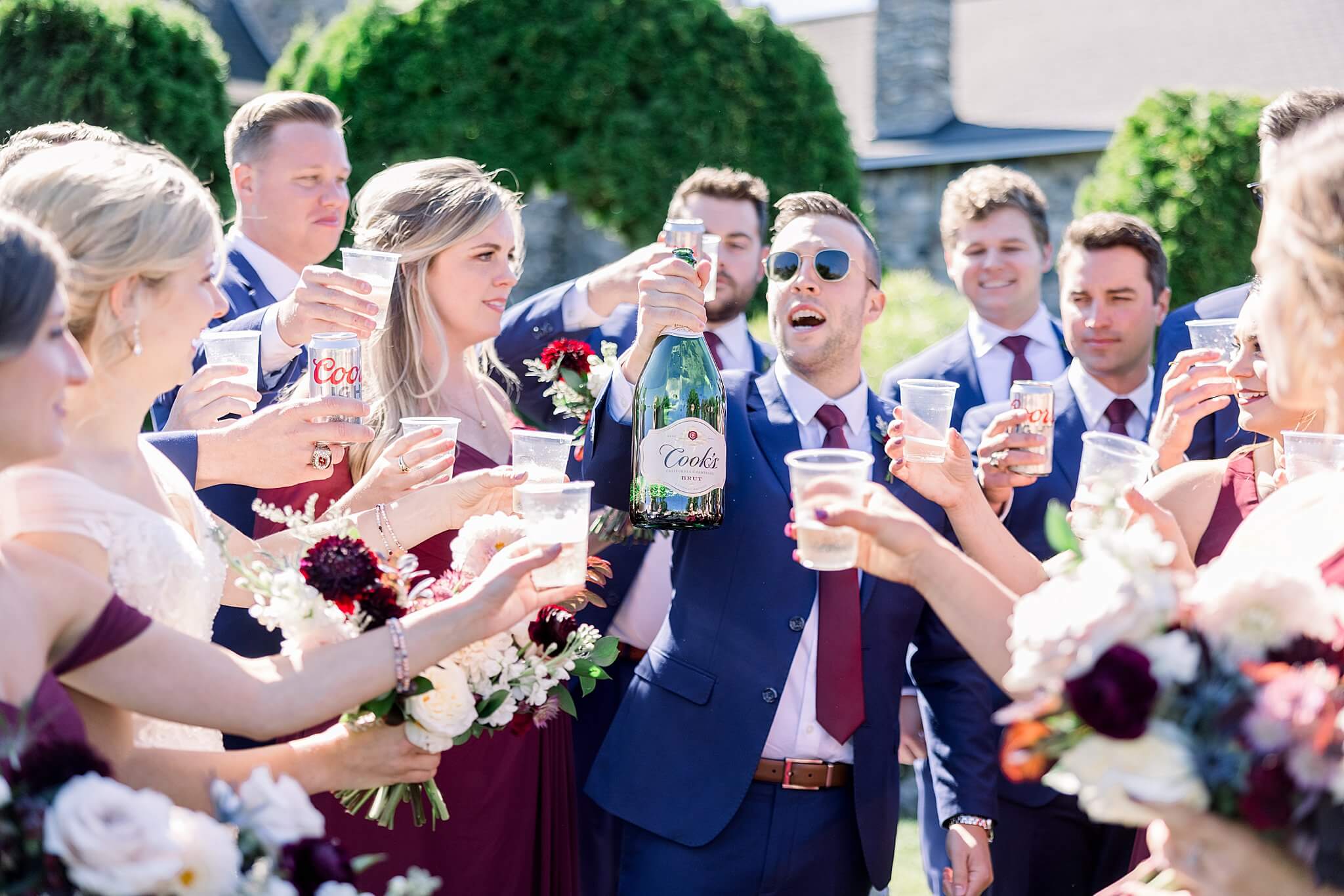 Wedding party pops champagne and toast during Castle Farms wedding.