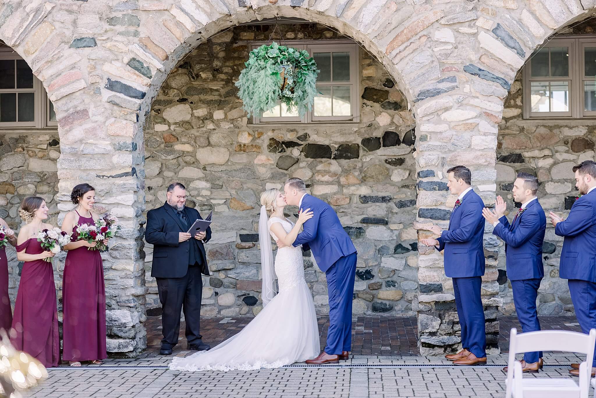 Bride and groom share first kiss during their Queen's Courtyard wedding at Castle Farms.