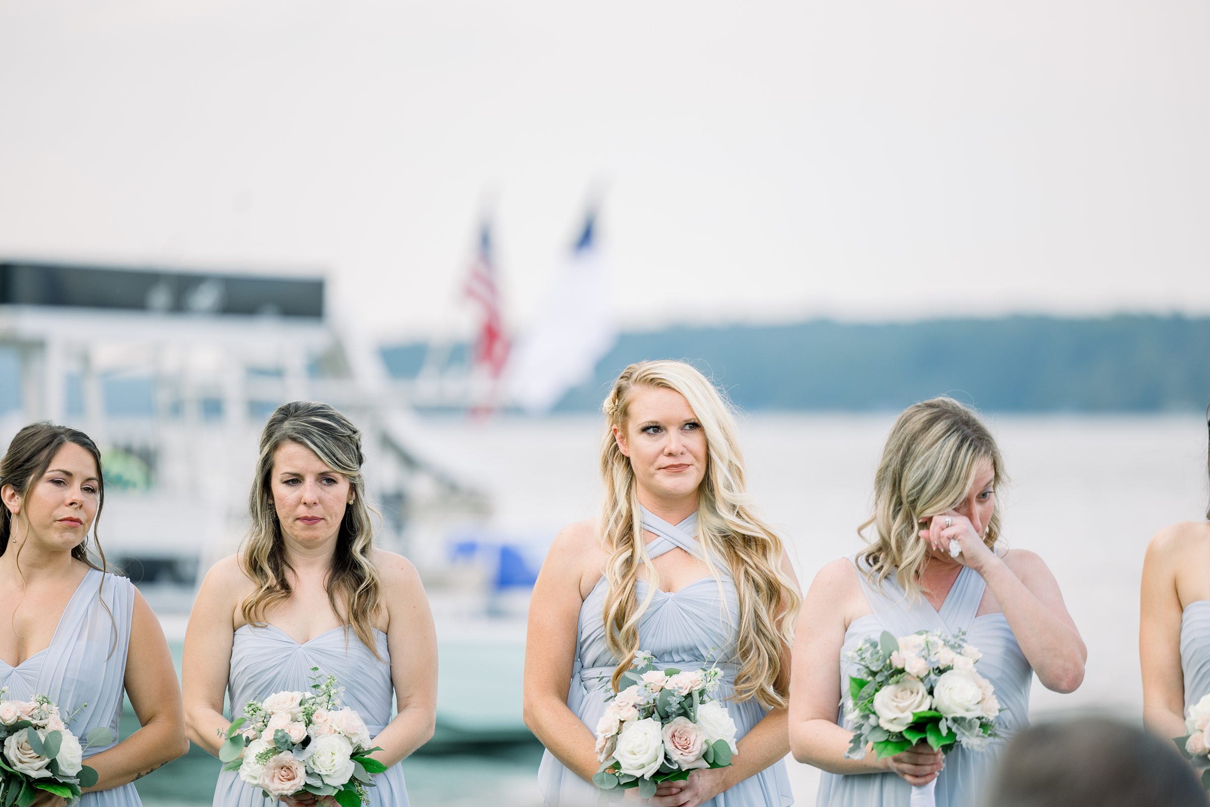 Bridesmaids cry during wedding ceremony at The Boathouse on Lake Charlevoix.