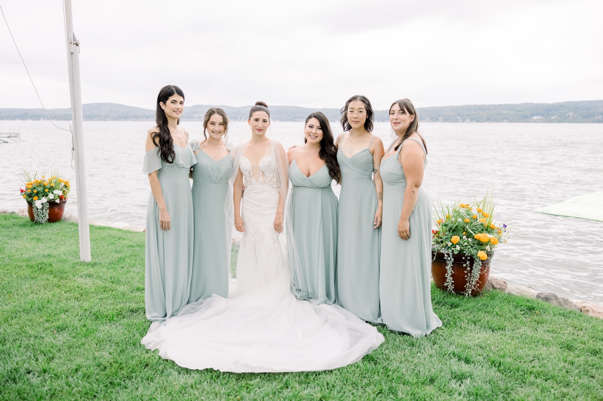Alyssa and her bridesmaids standing on the edge of the Perry Hotel property overlooking the water.