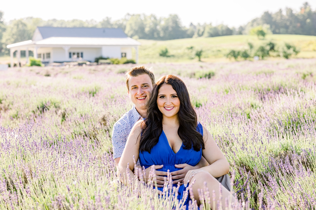 Lindsey sitting in Austin's lap as they both sit in the middle of a lavender field.