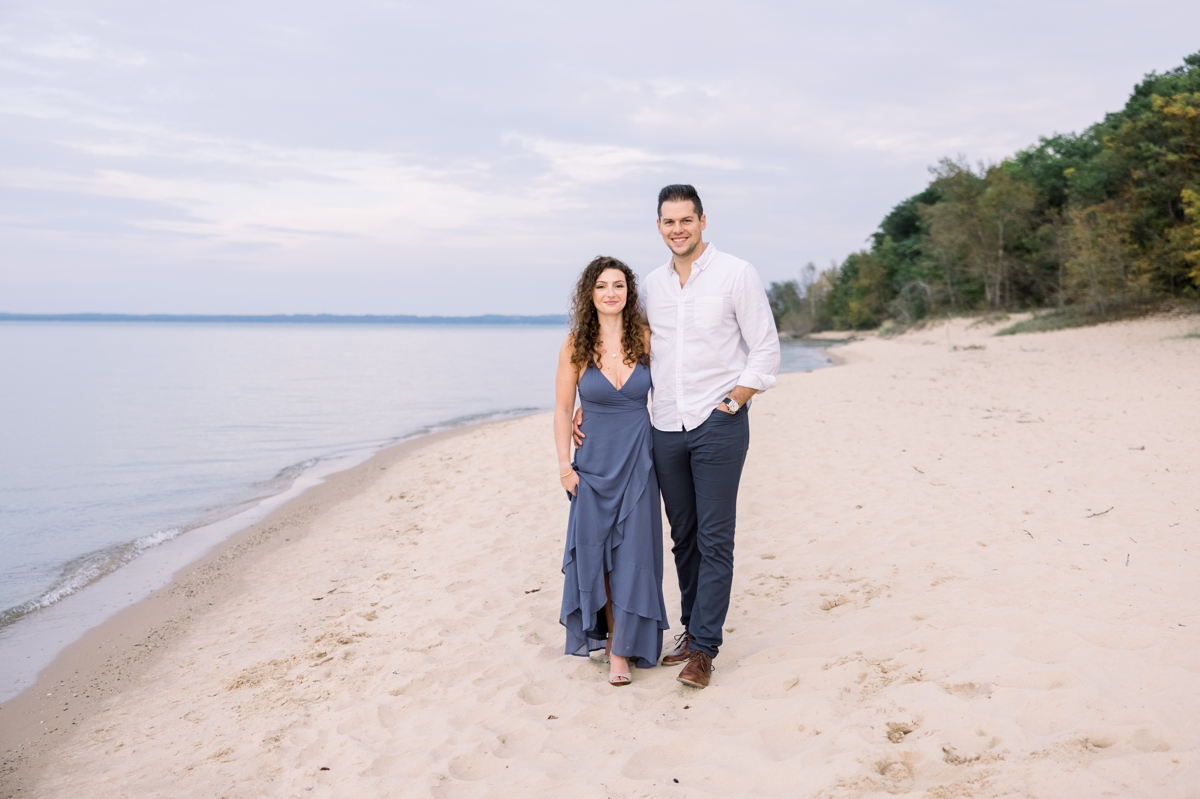 Marissa and Alex holding hands on the beach during their engagement session with Mandie Forbes Photography.