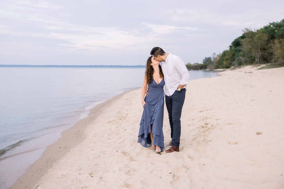Marissa and Alex kissing on the ocean's edge during their engagement session with Mandie Forbes Photography.