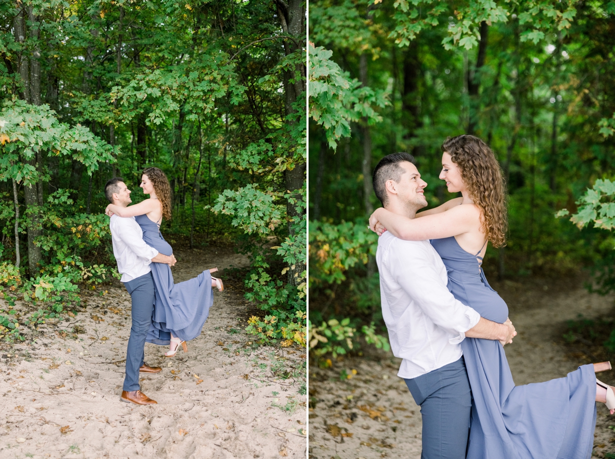Alex picking Marissa up while she smiles down at him during their engagement session.